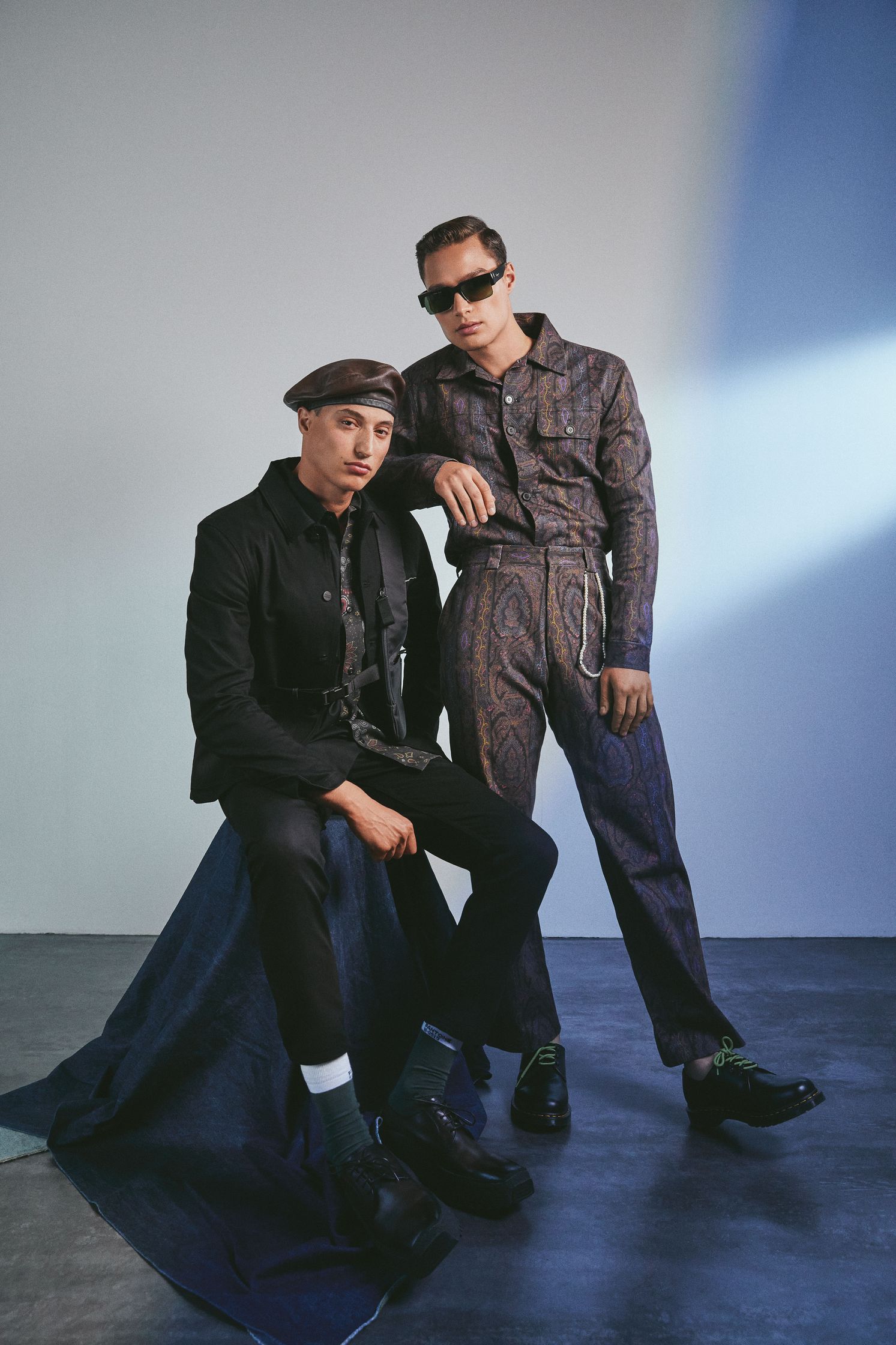 two men posing for a photo in a studio