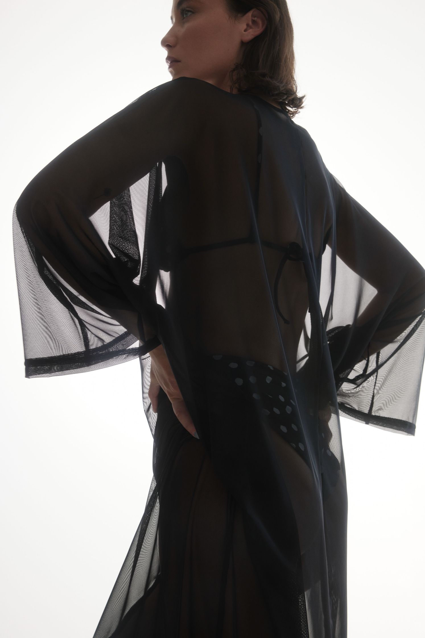 the model is wearing a black sheer robe