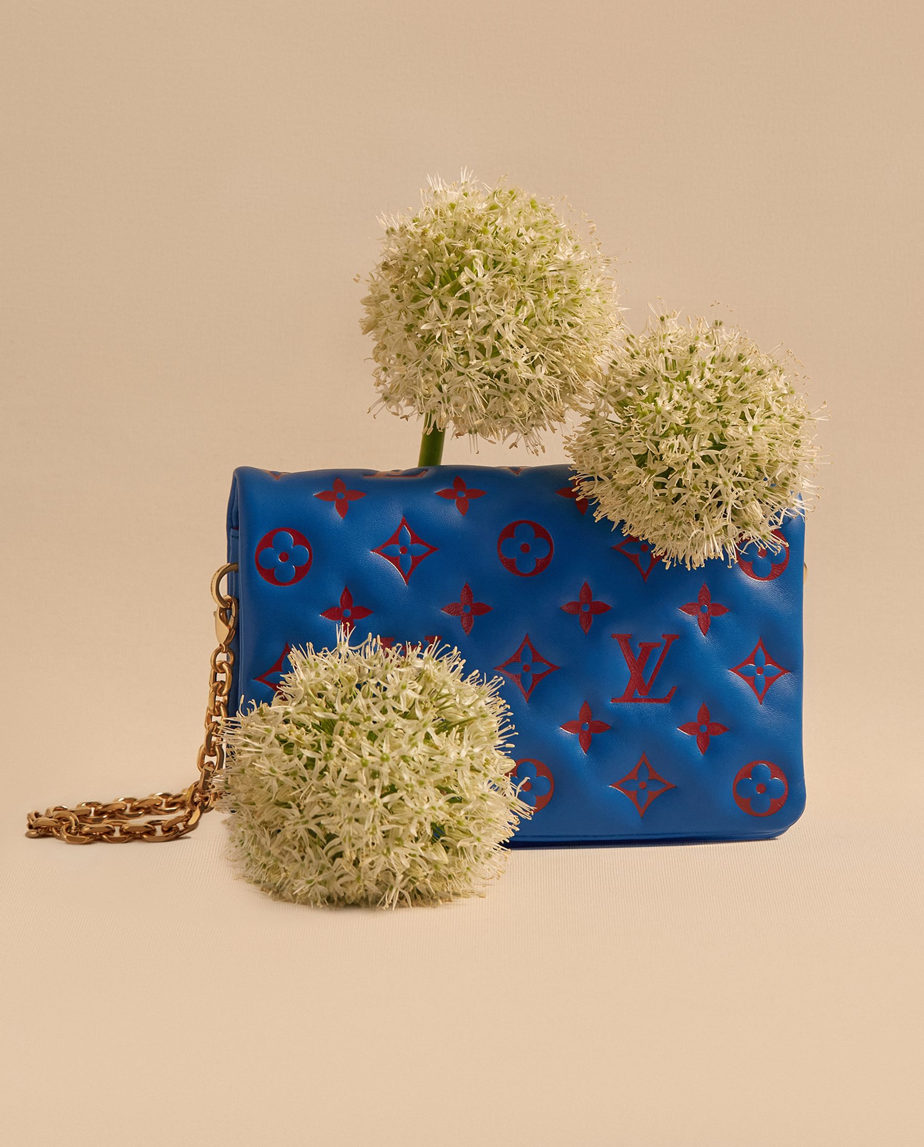 a blue louis vuitton purse with flowers on it