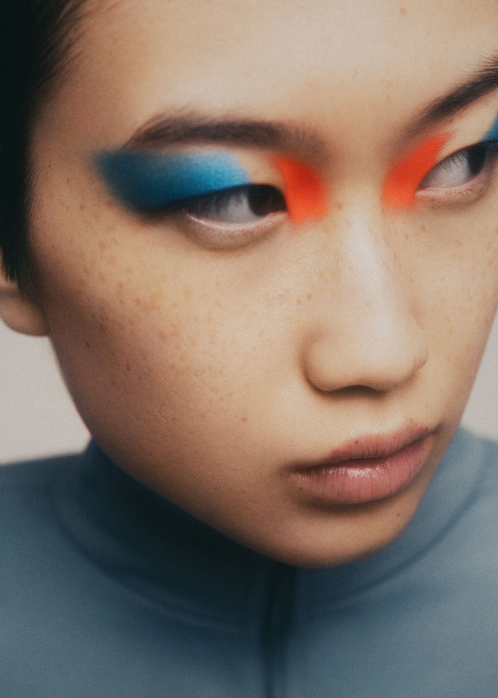 a woman with blue and orange eye makeup