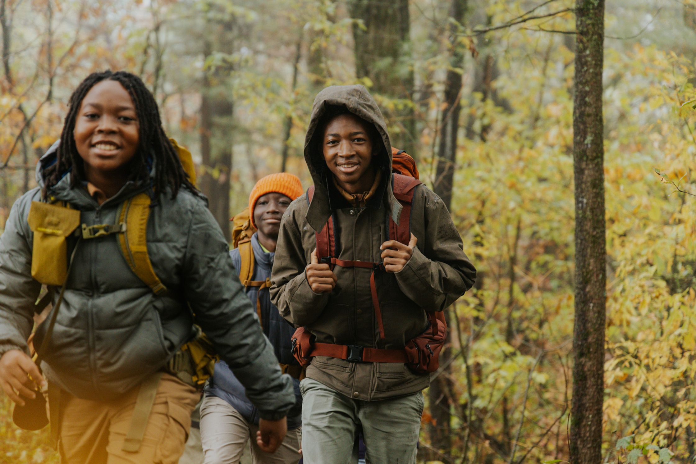 a group of young people hiking in the woods