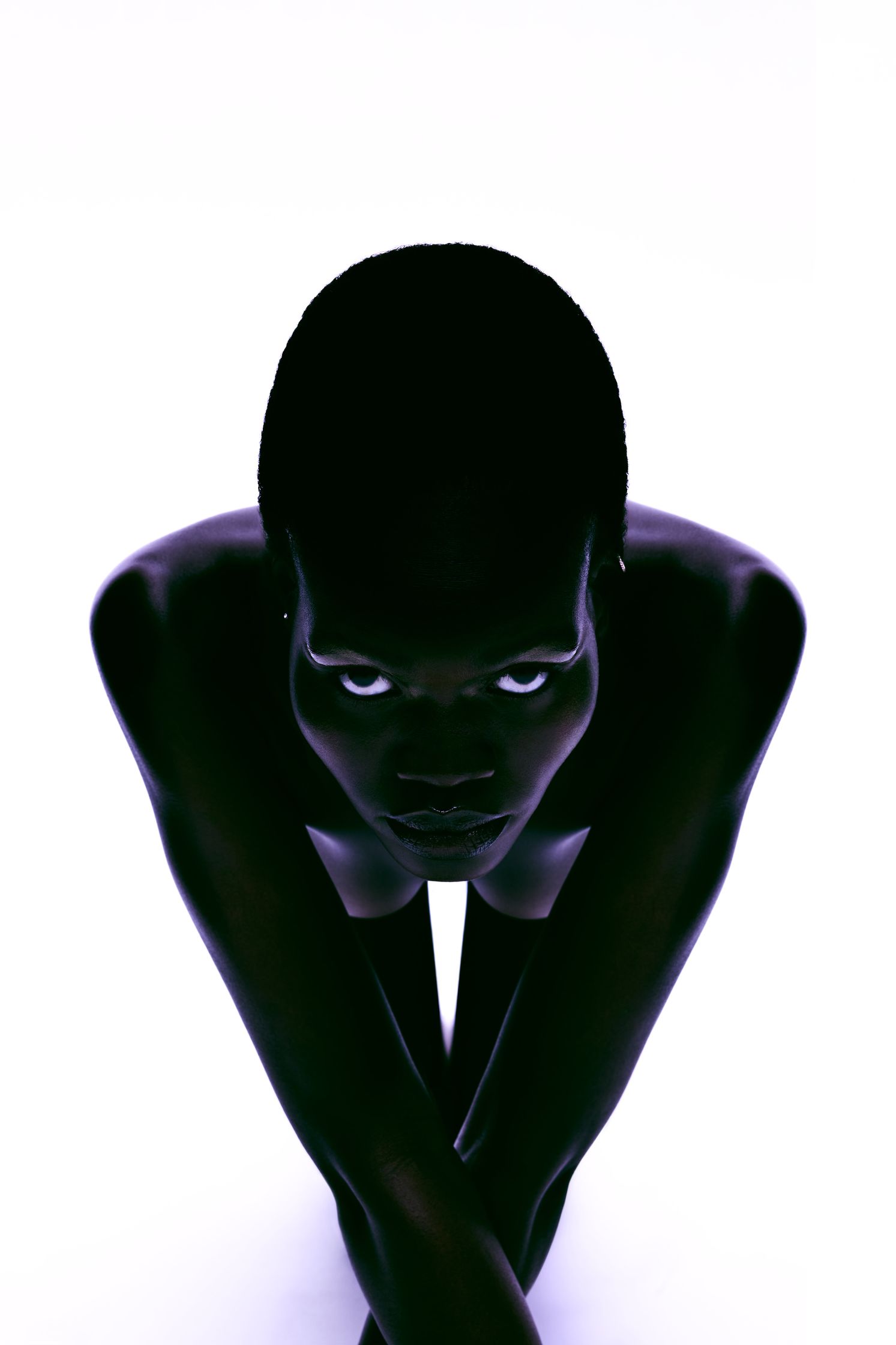 a black man crouching down on a white background