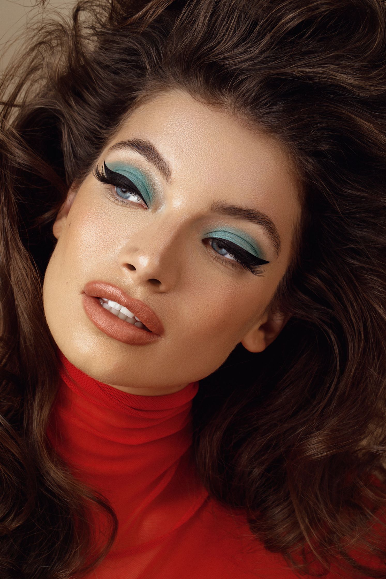 a woman with long hair and blue eye makeup