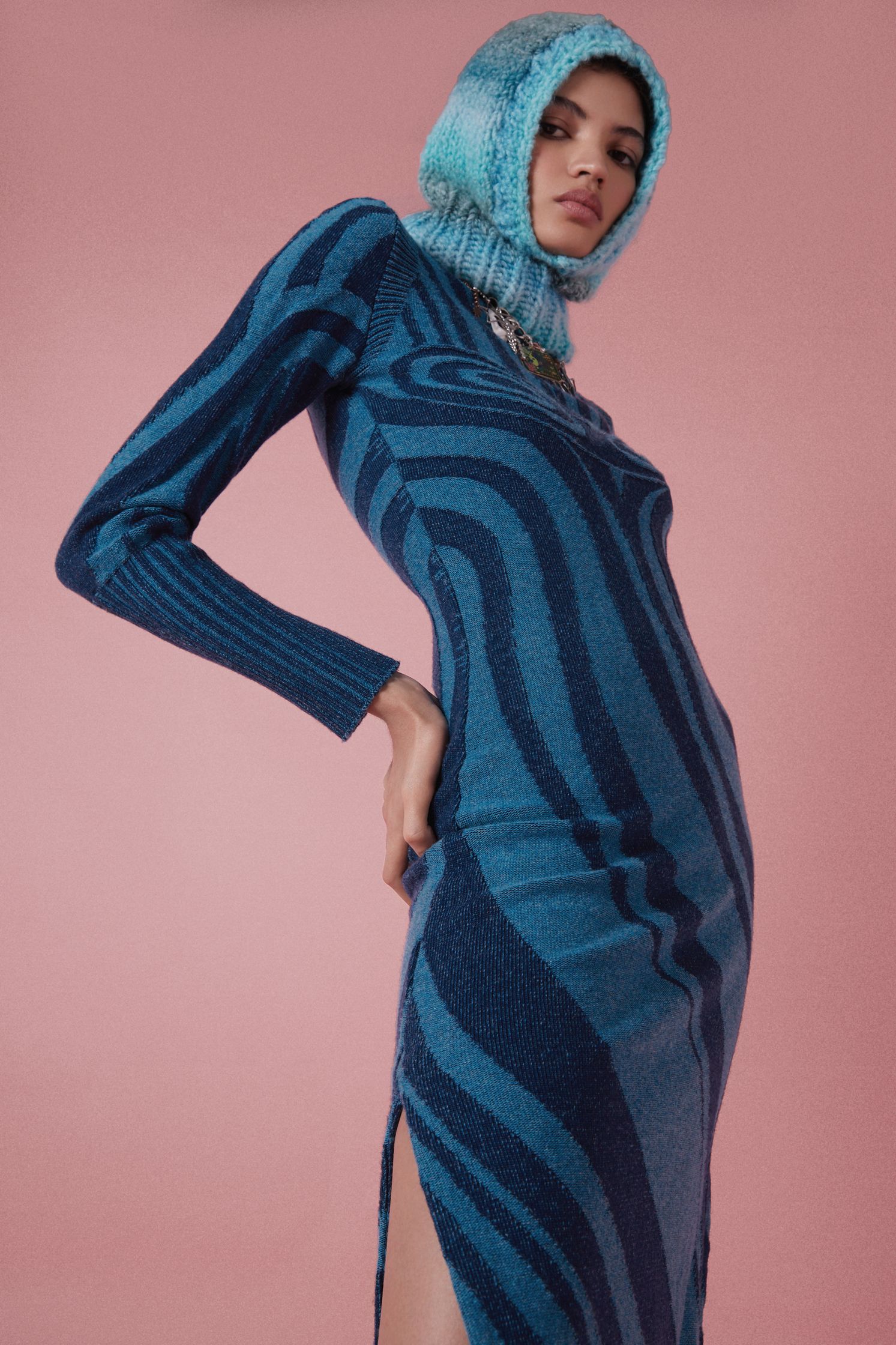 the model is wearing a blue striped dress with a hood