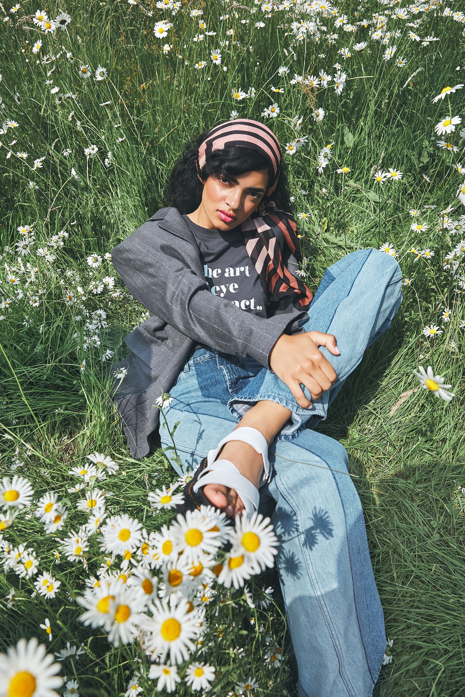 a woman laying in a field of daisies