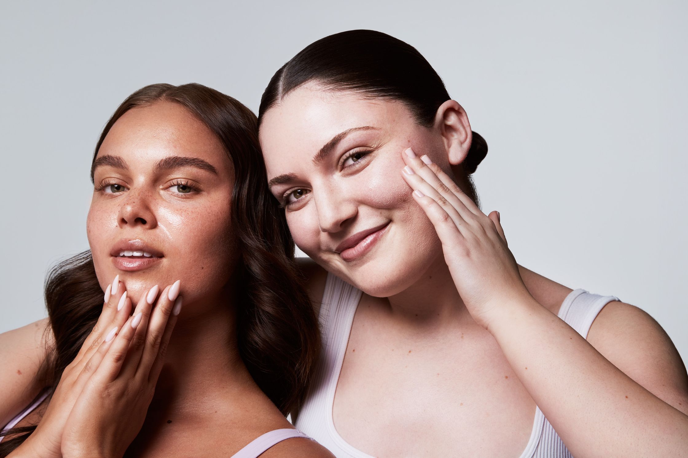 two women posing for a photo with their hands on their face