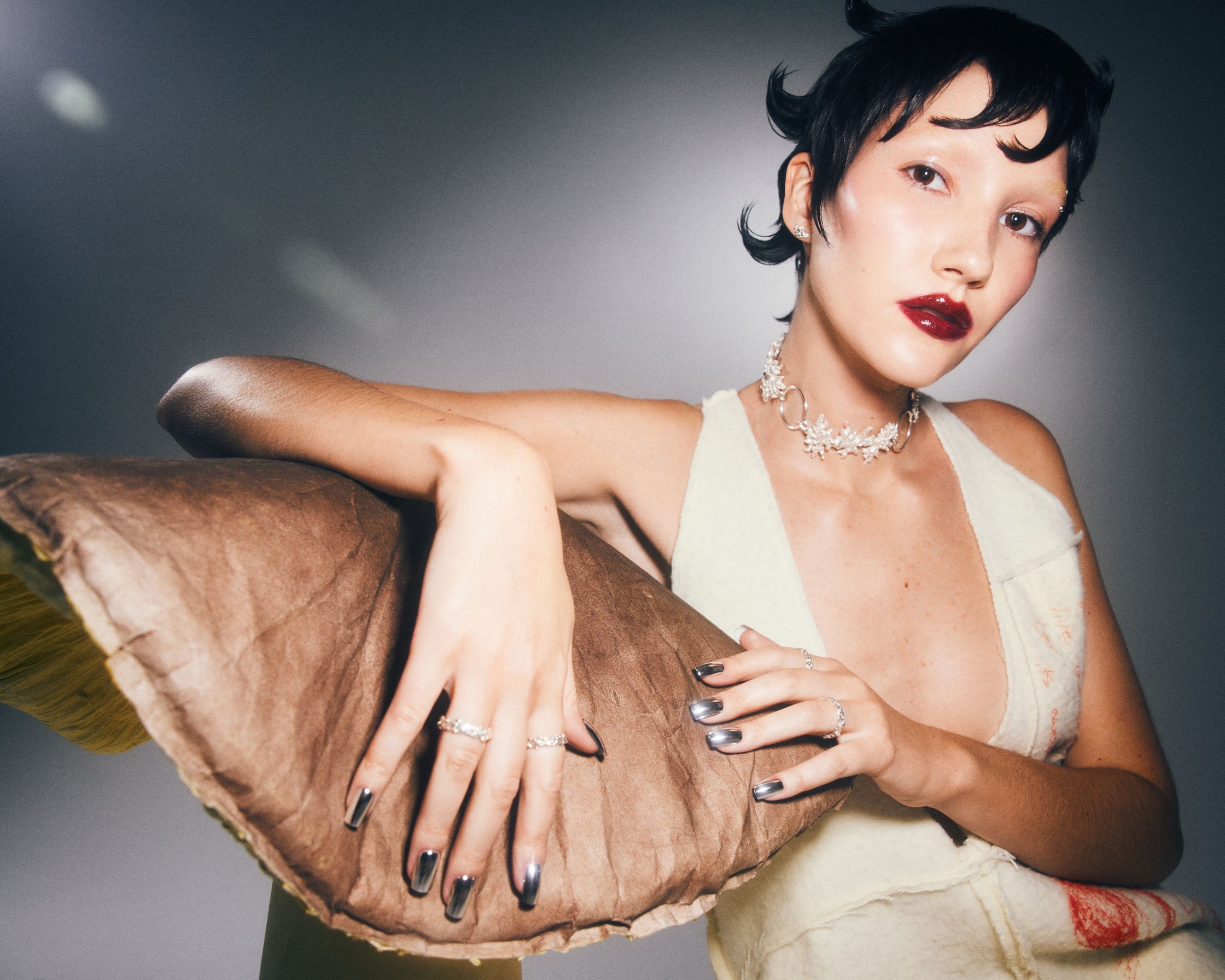 a woman is posing with a brown pillow