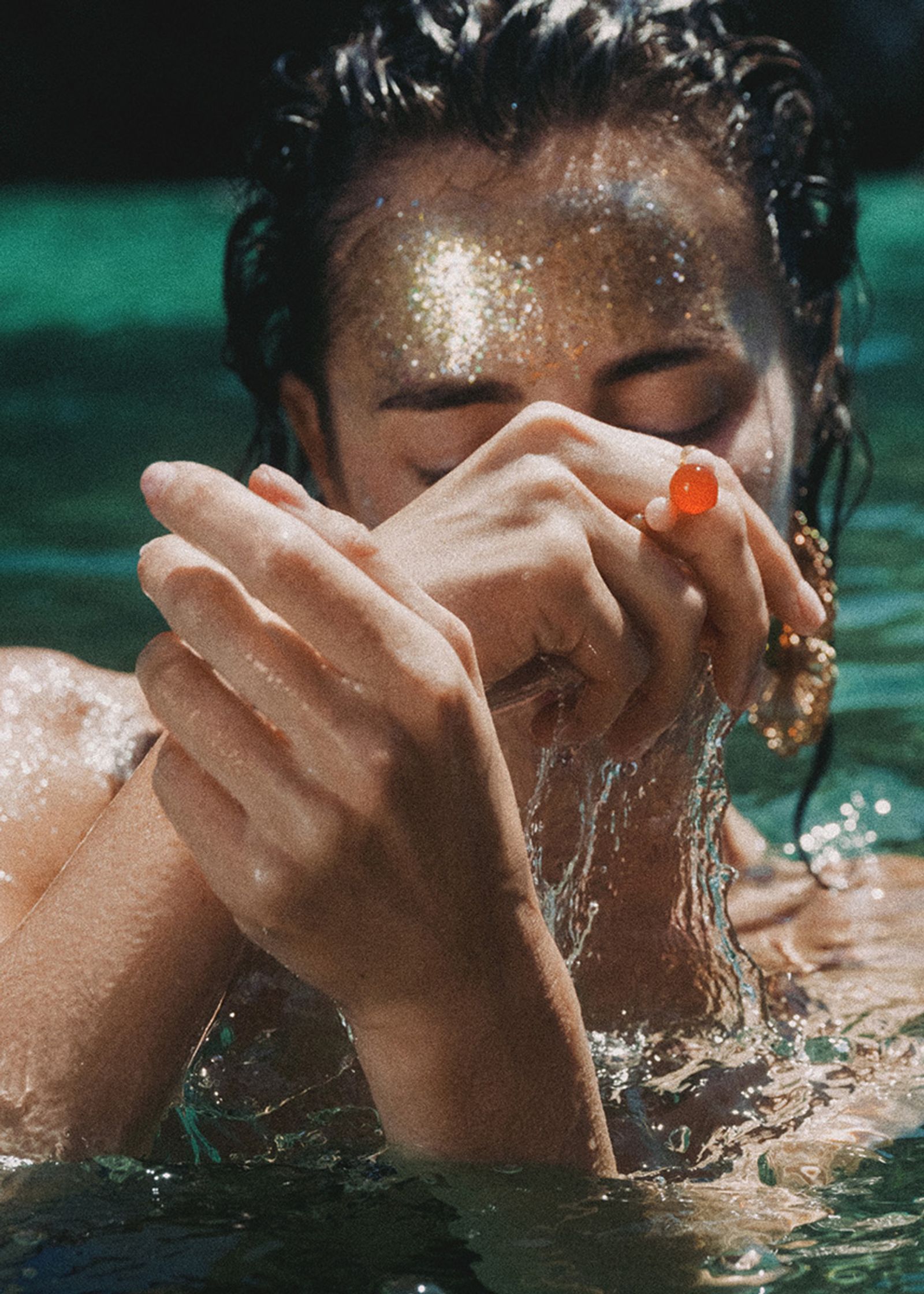 a woman in the water with a gold ring on her face
