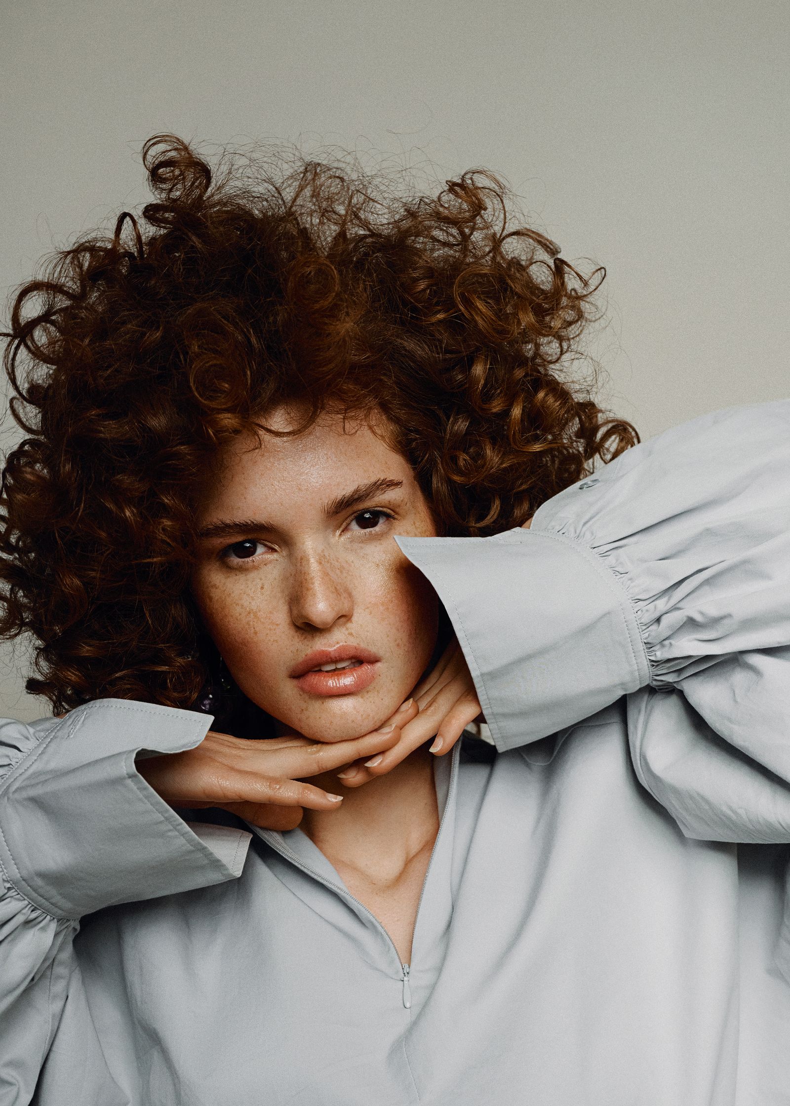 a woman with curly hair posing for a magazine