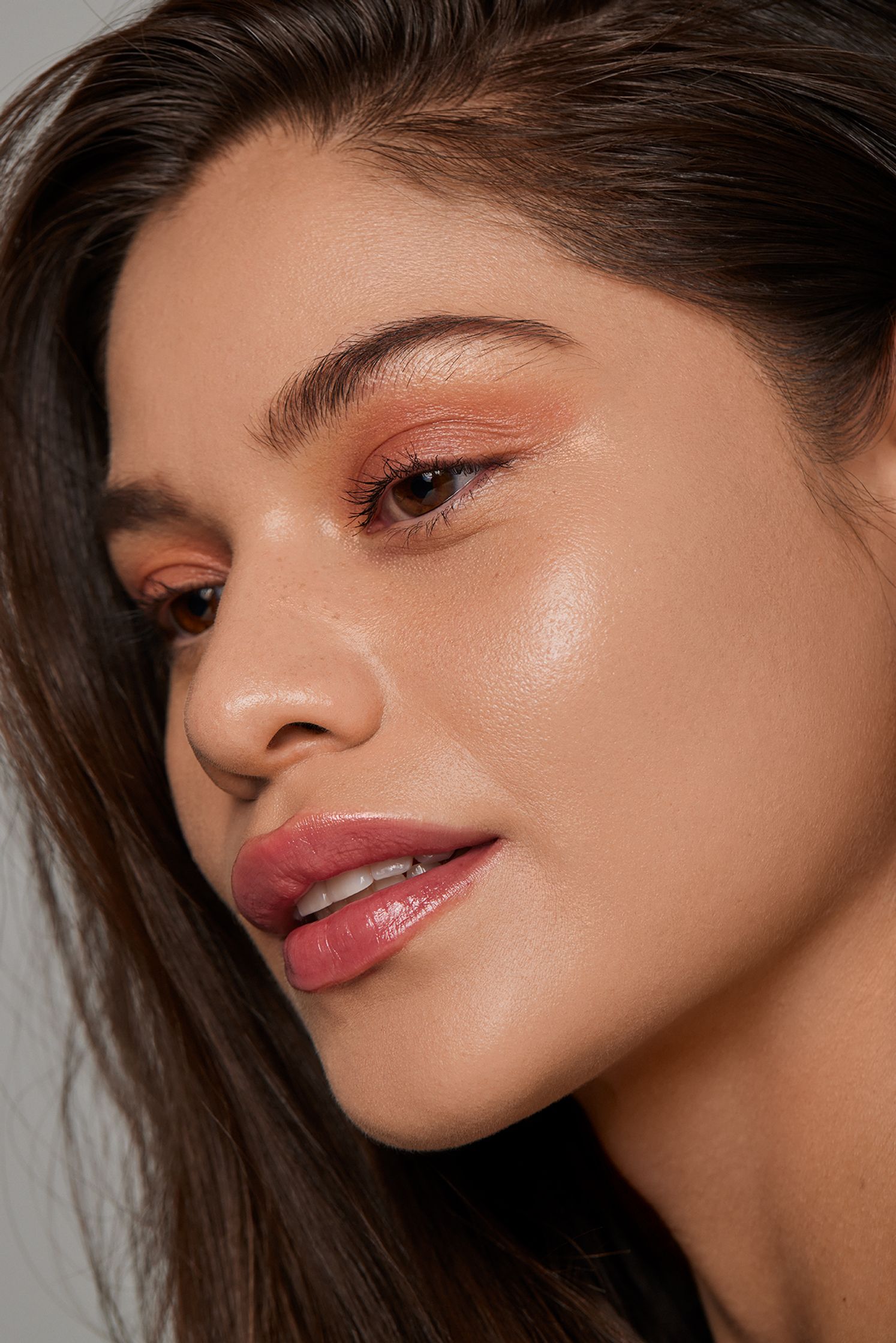 a woman with long brown hair and orange eyeshadow