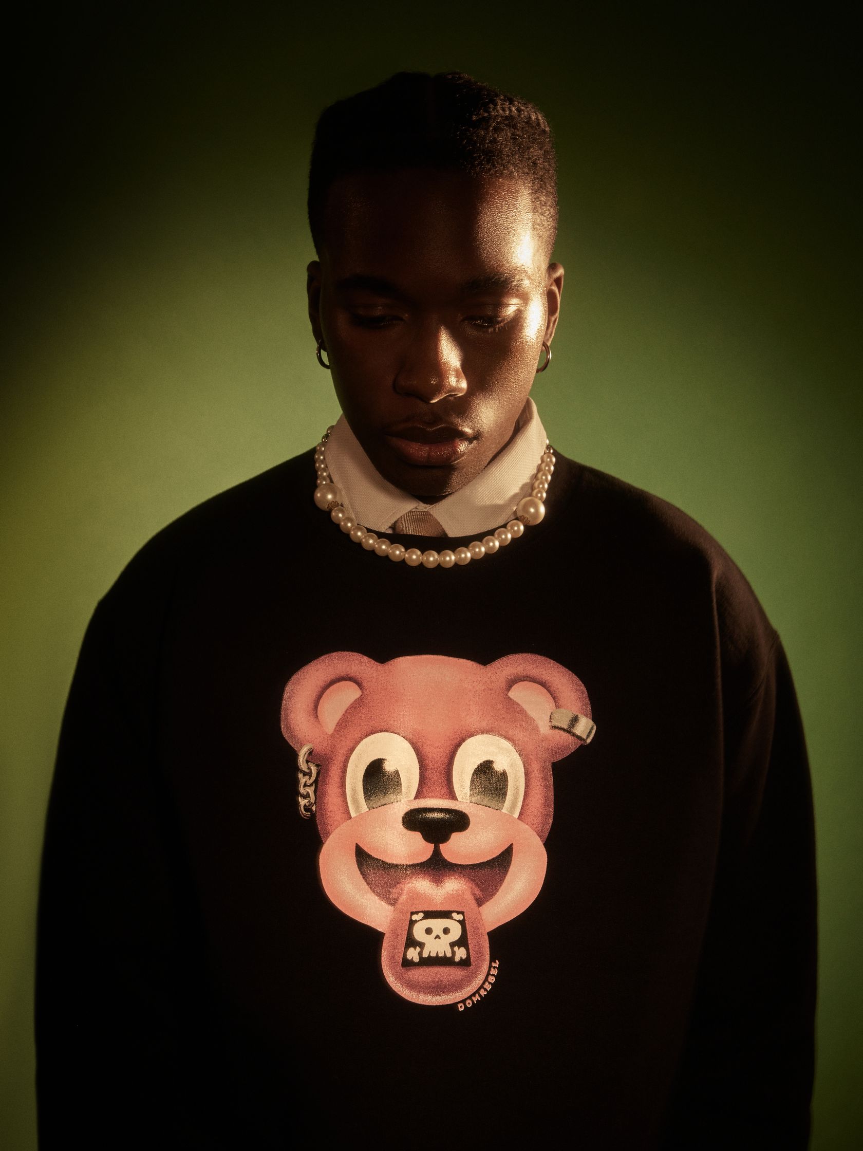 a black man wearing a sweater with a bear on it