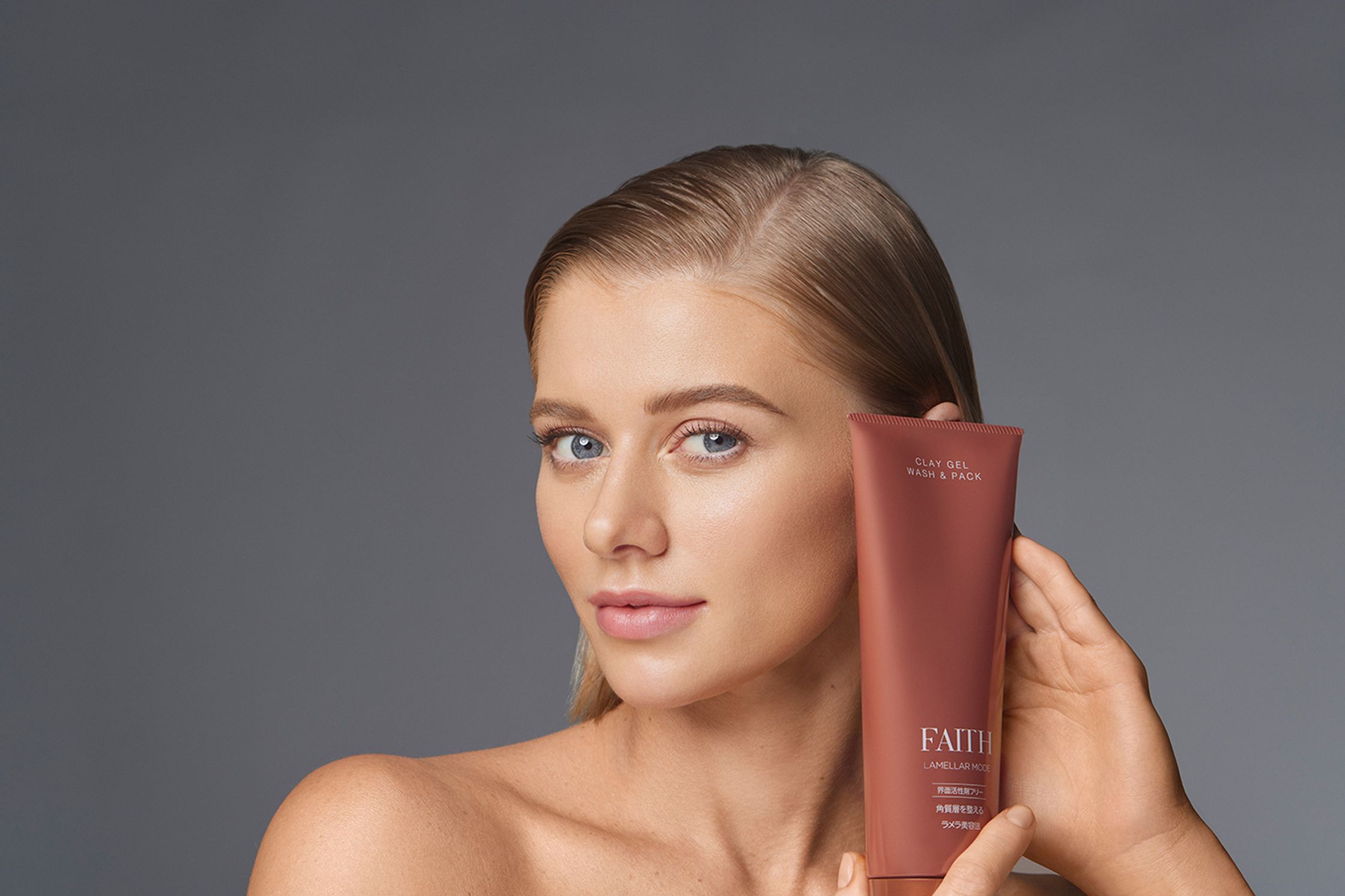 a woman holding a tube of skin care product