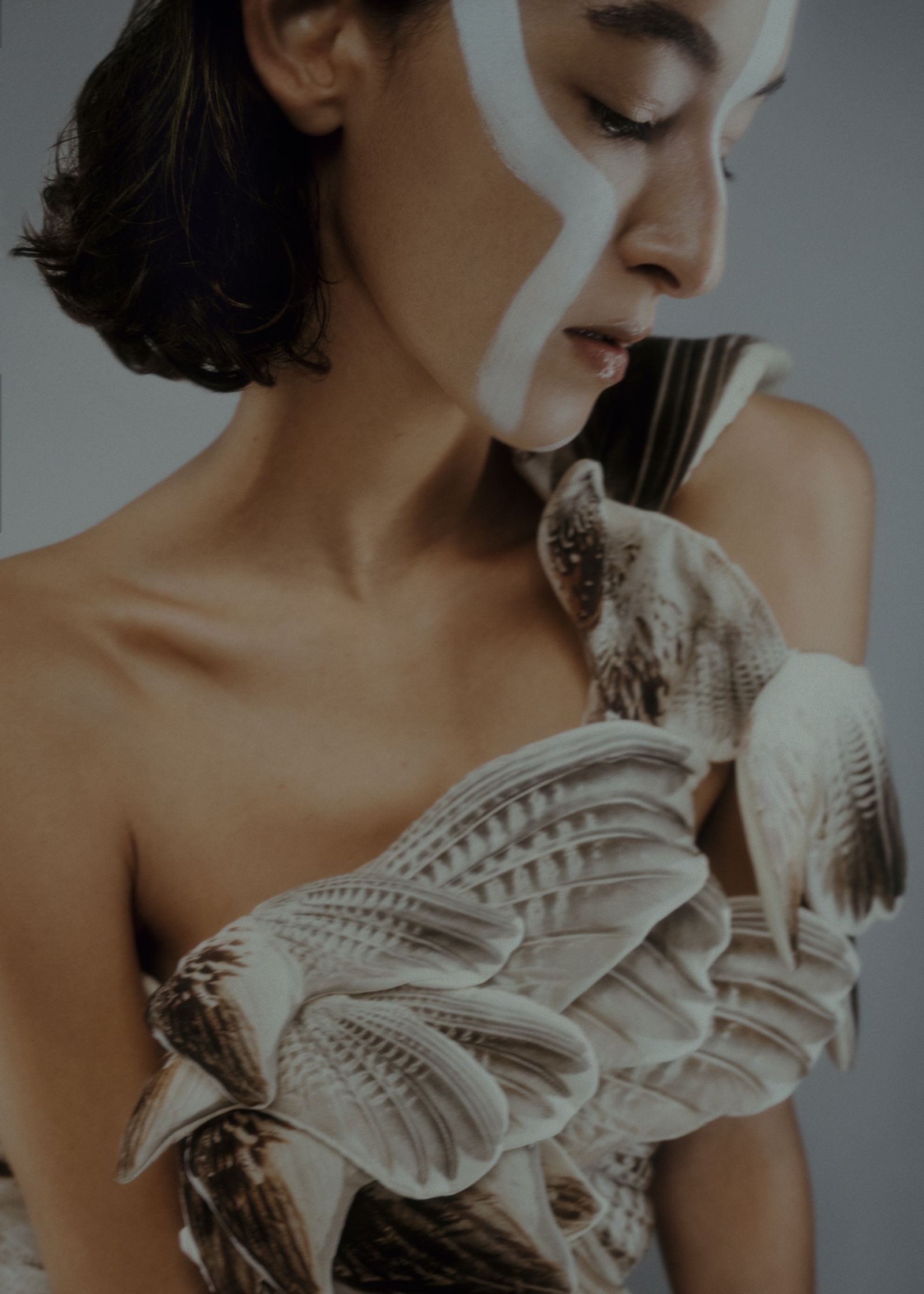 a woman wearing a dress with feathers on it