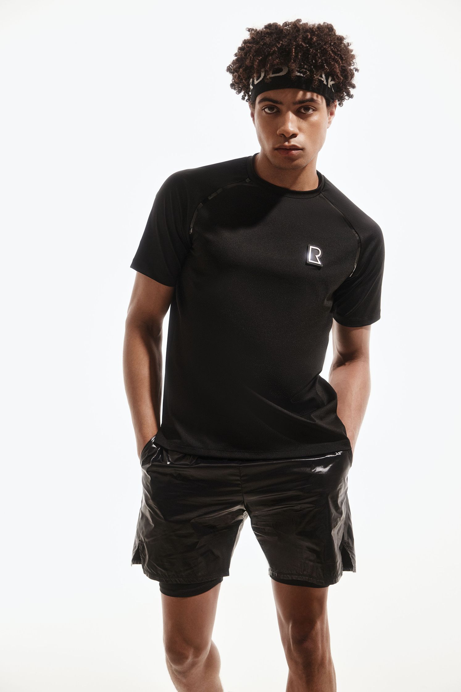a man wearing a black t - shirt and shorts