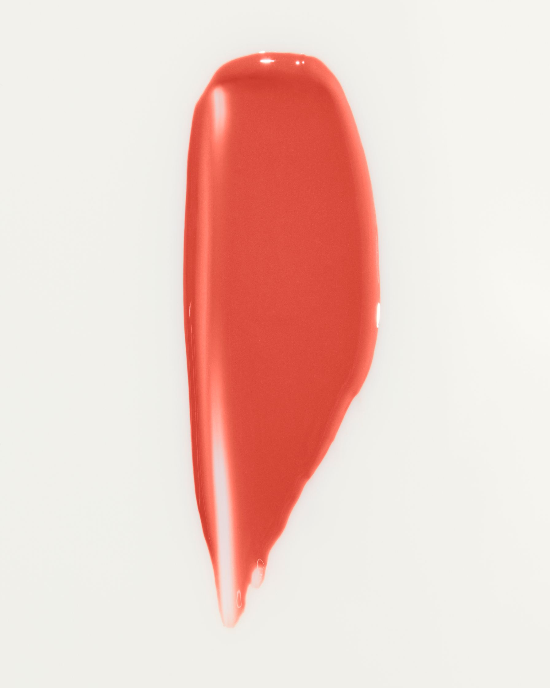 a red liquid lipstick on a white surface