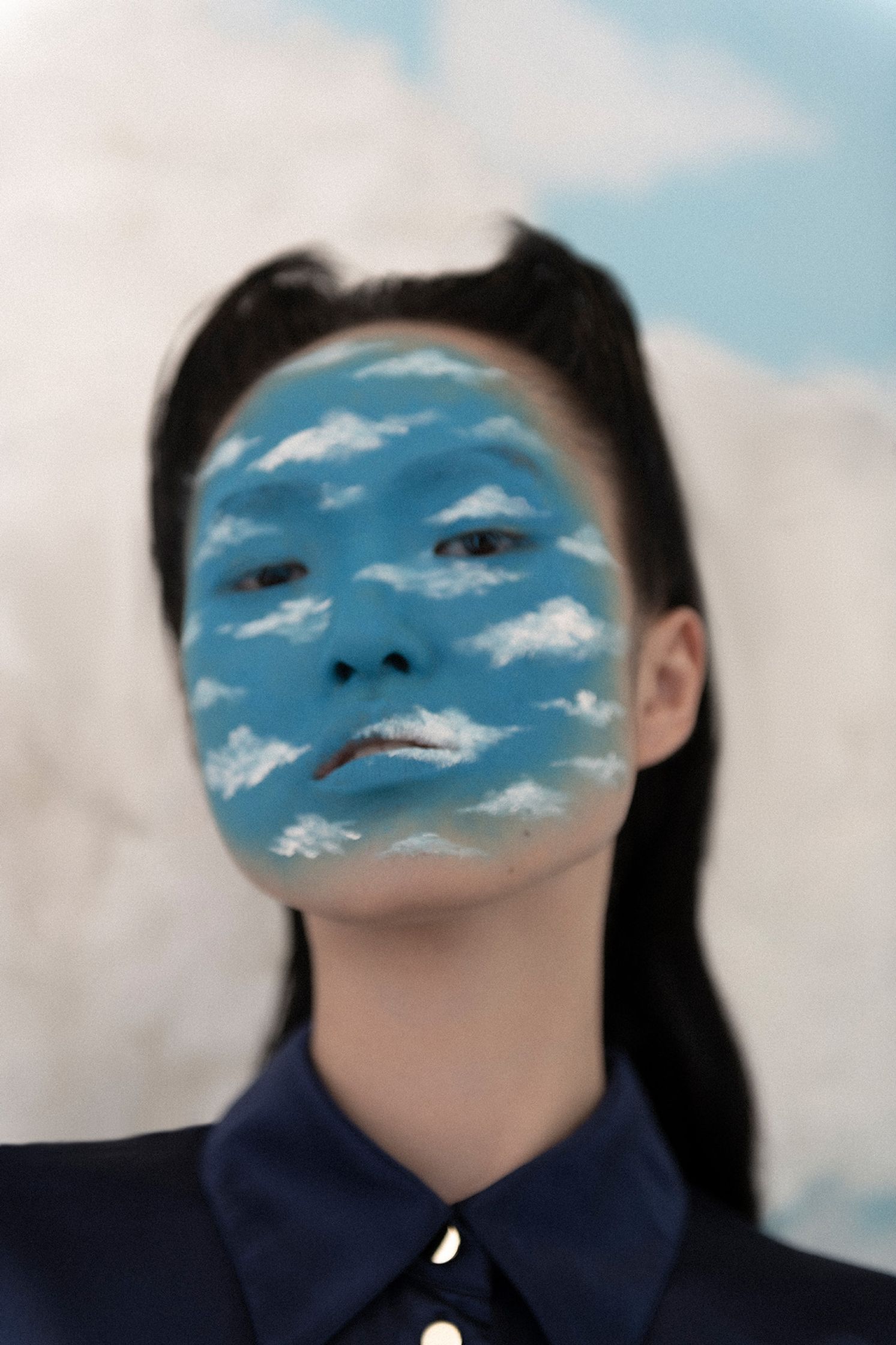 a woman with clouds painted on her face