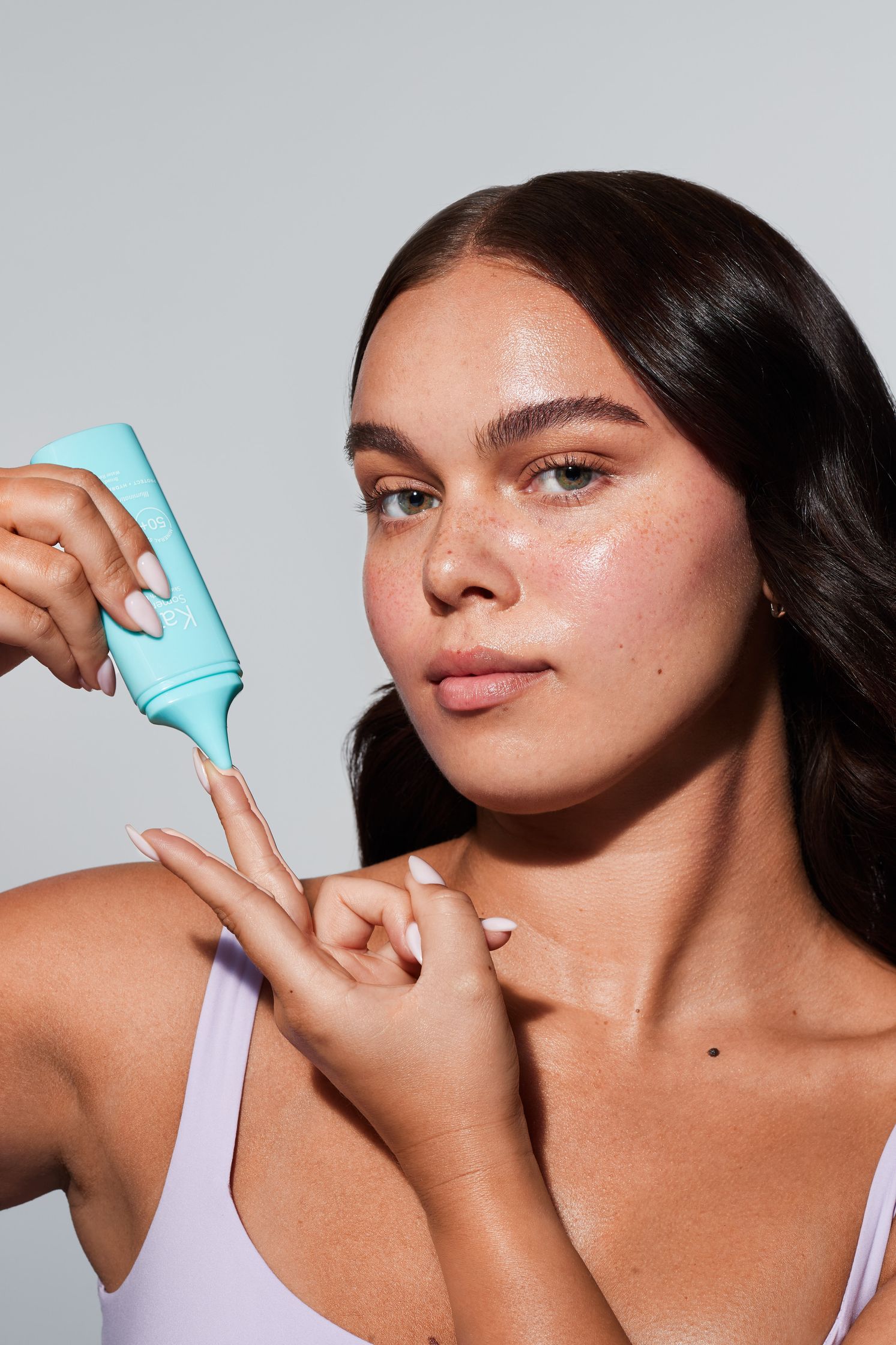 a woman is holding a bottle of sunscreen