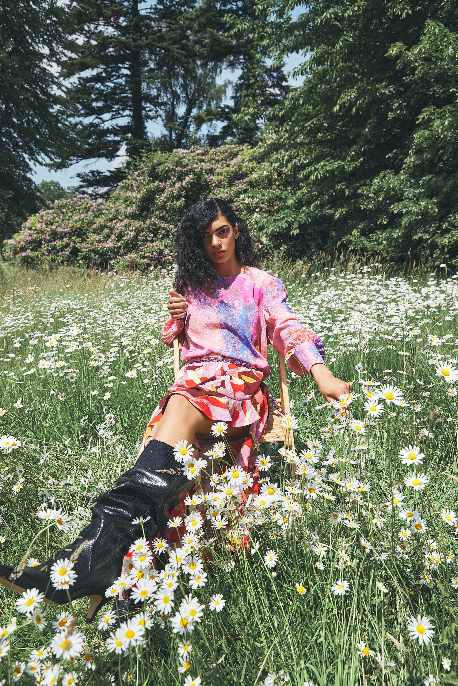 a woman sitting in a field of daisies