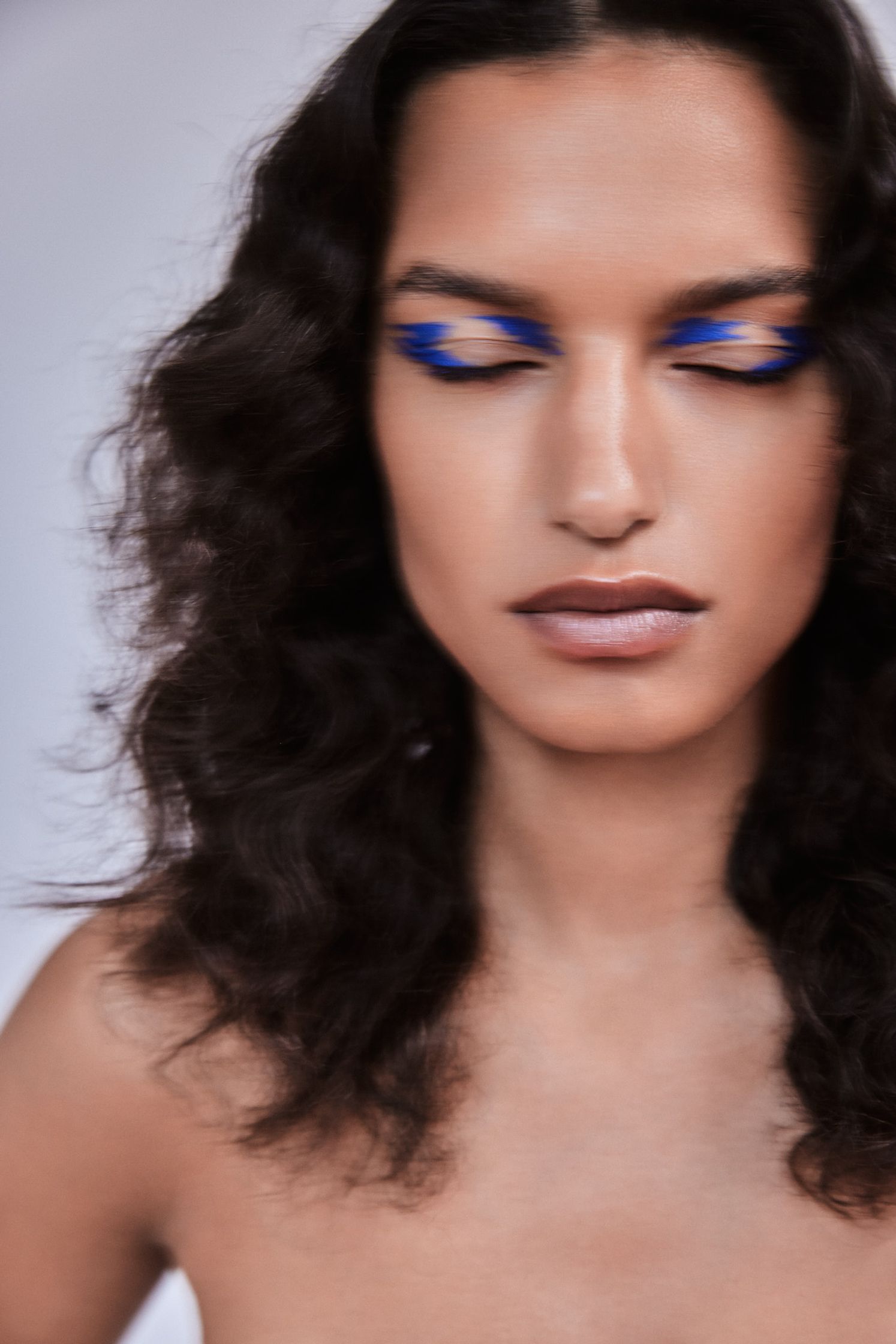 a woman with blue eye makeup is posing for a photo