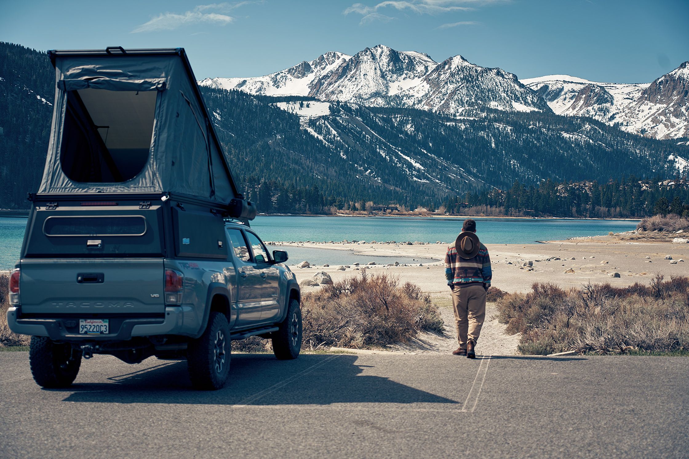 a person standing in front of a truck with a tent on top