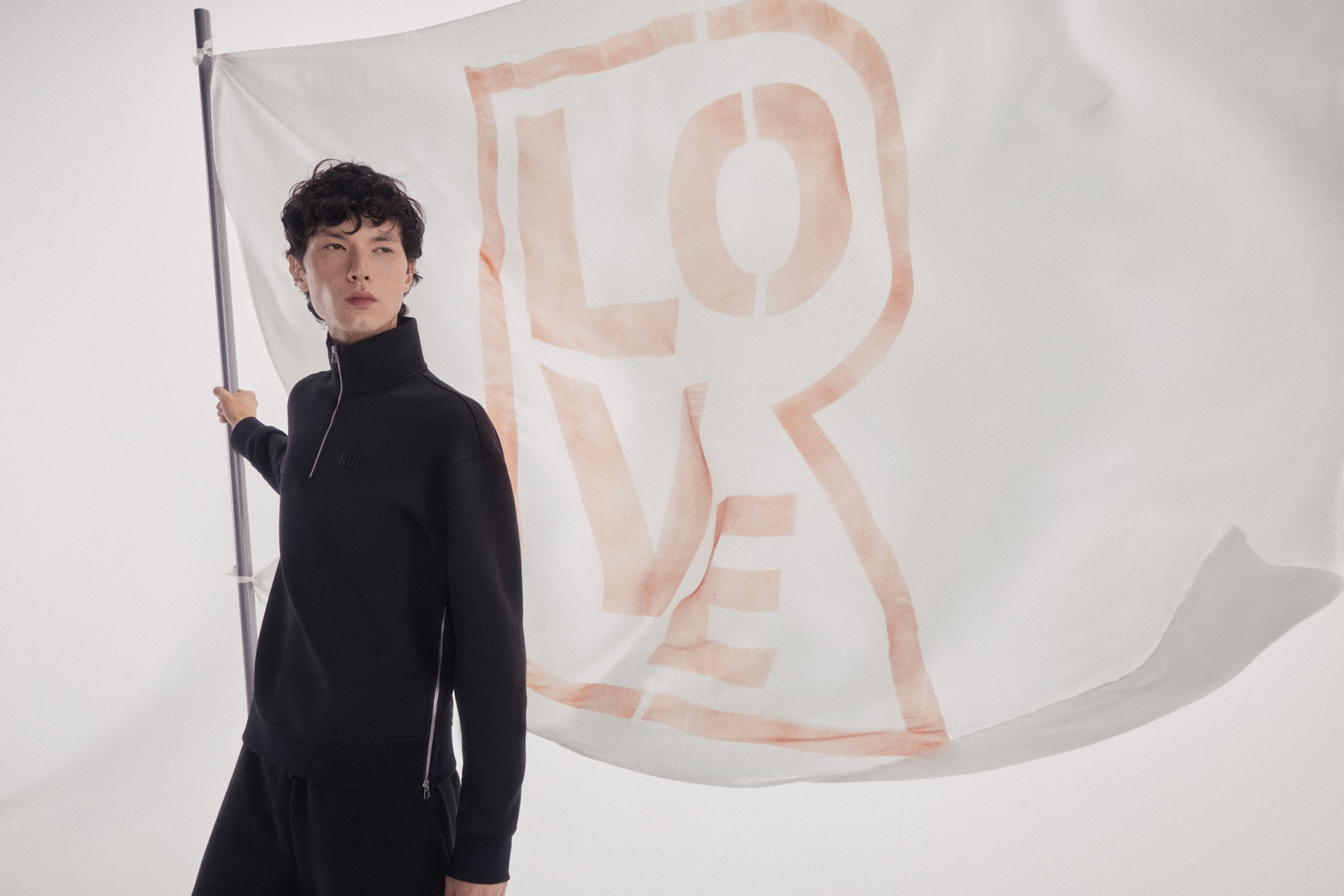 a model holding a flag with the word love on it