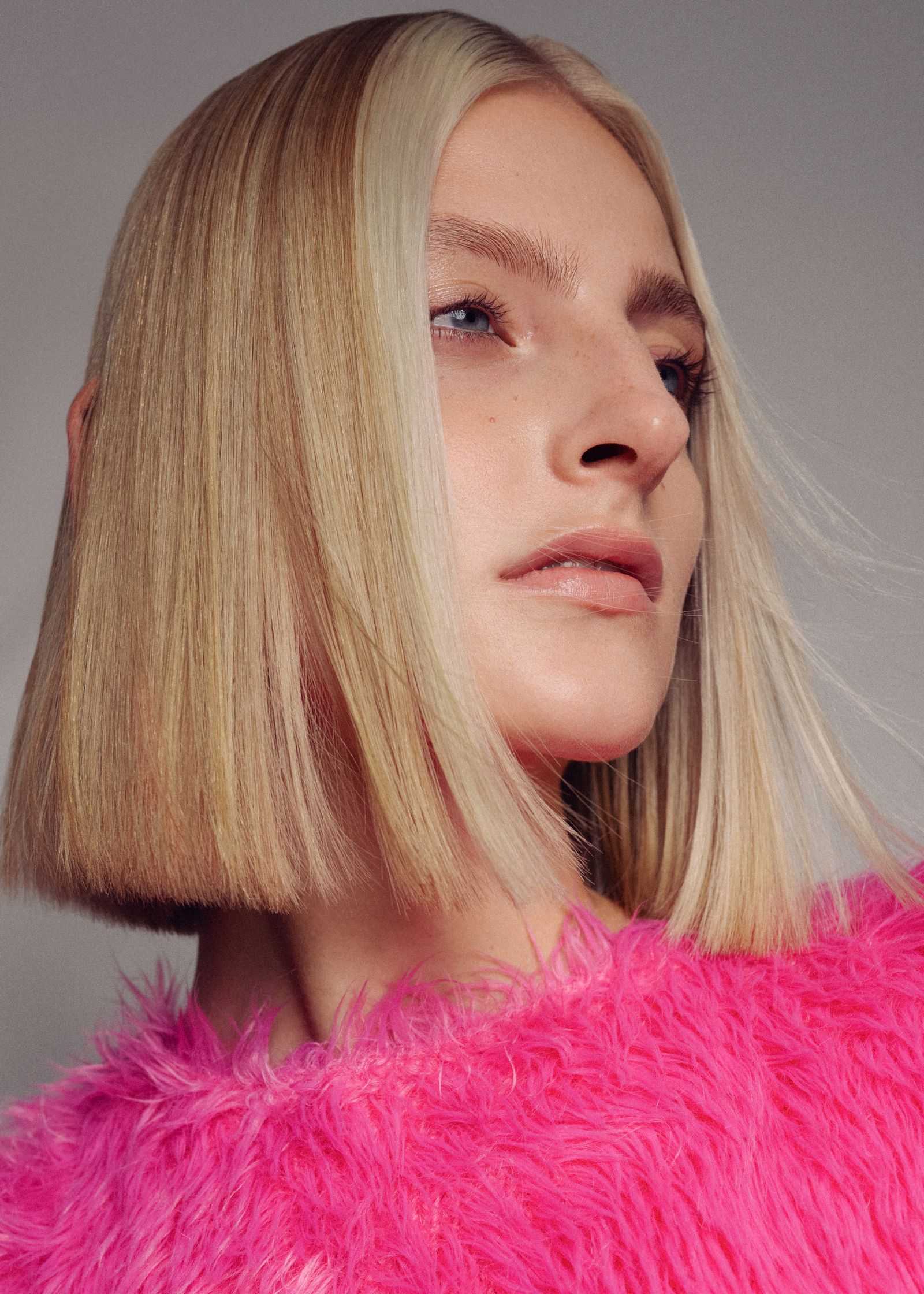 a woman in a pink furry sweater with blonde hair