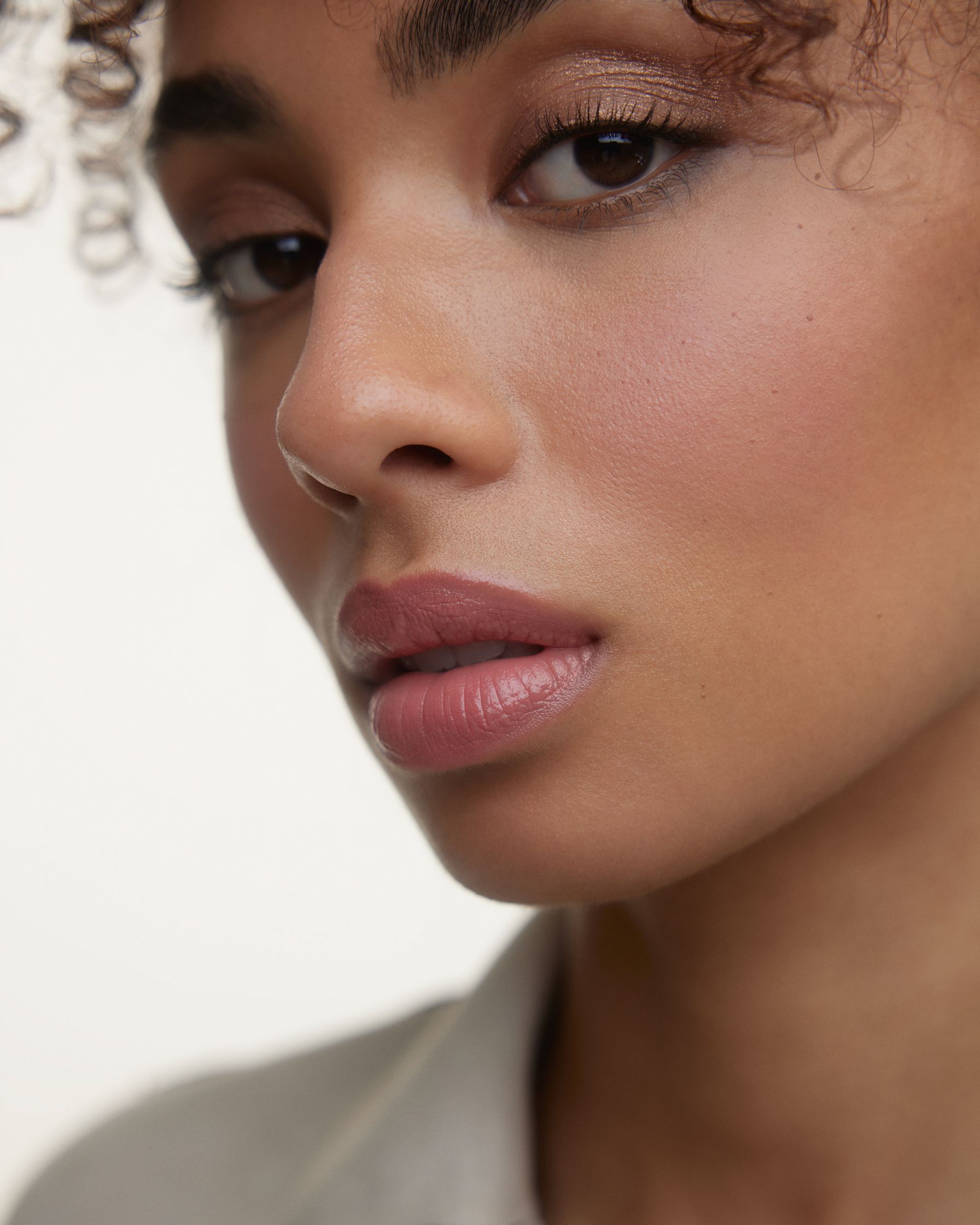 a woman with curly hair is looking at the camera