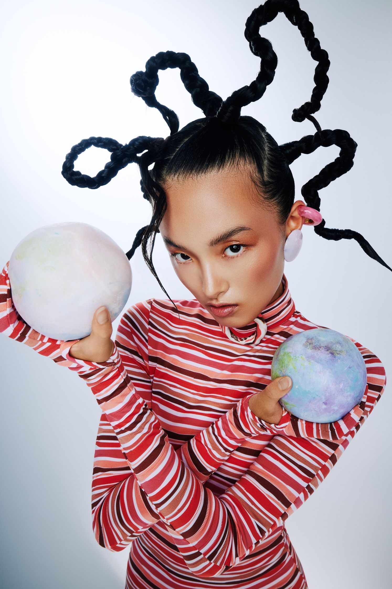 a woman with dreadlocks holding two balls