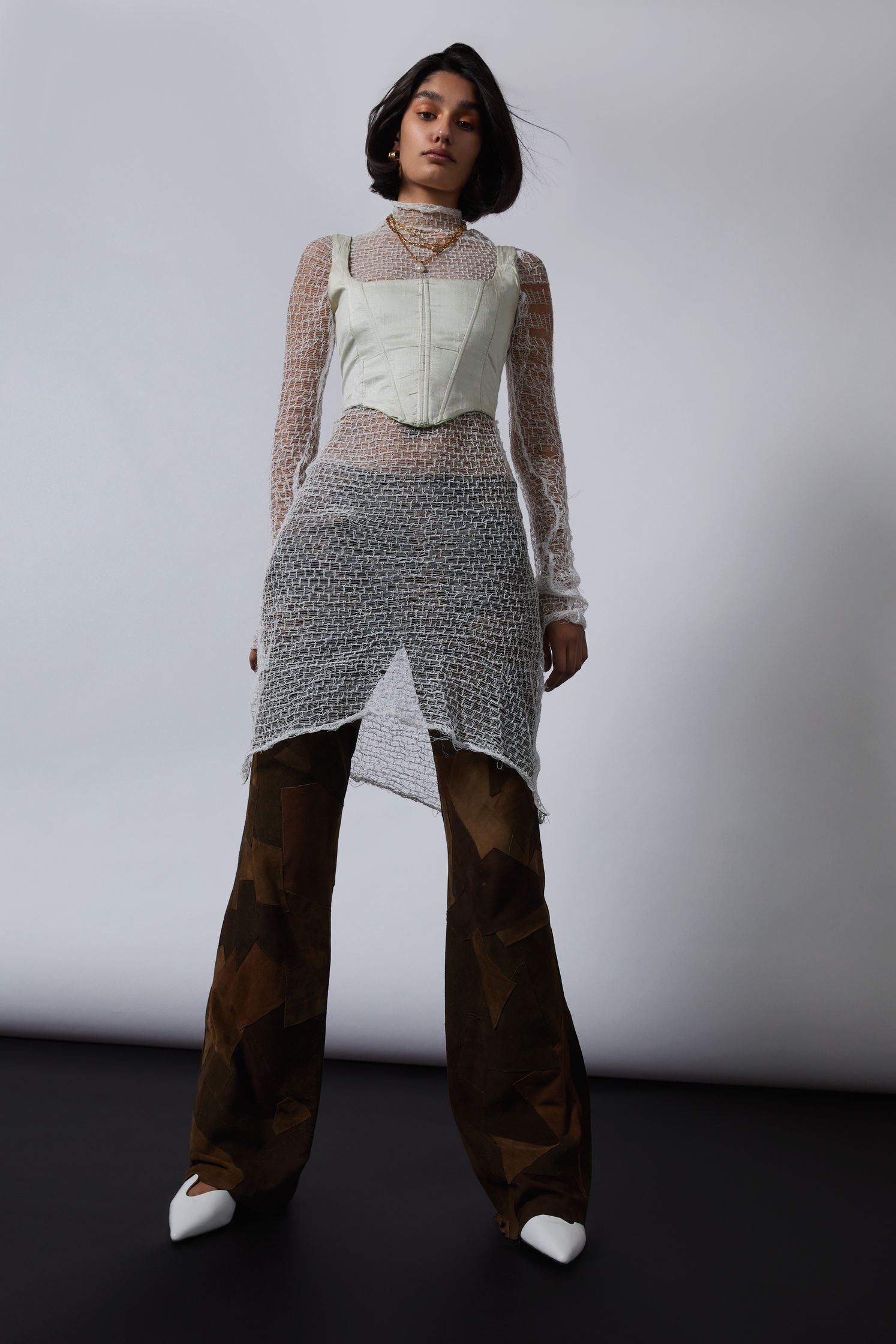 a model wearing a white sheer top and camouflage pants