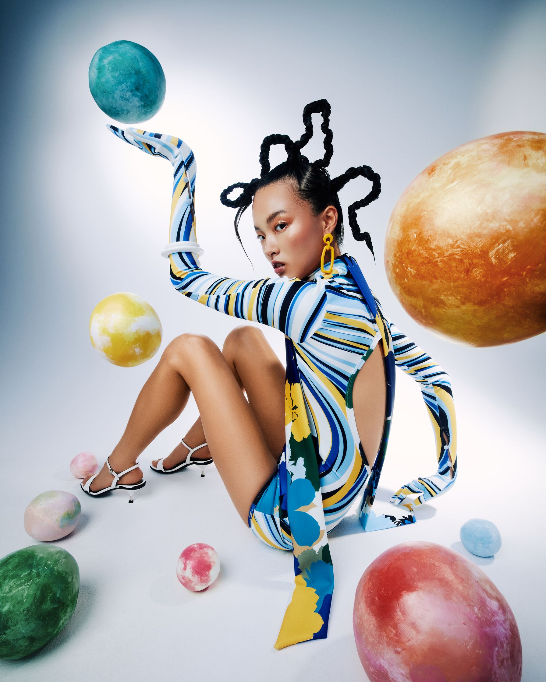 a woman in a colorful outfit posing with balls