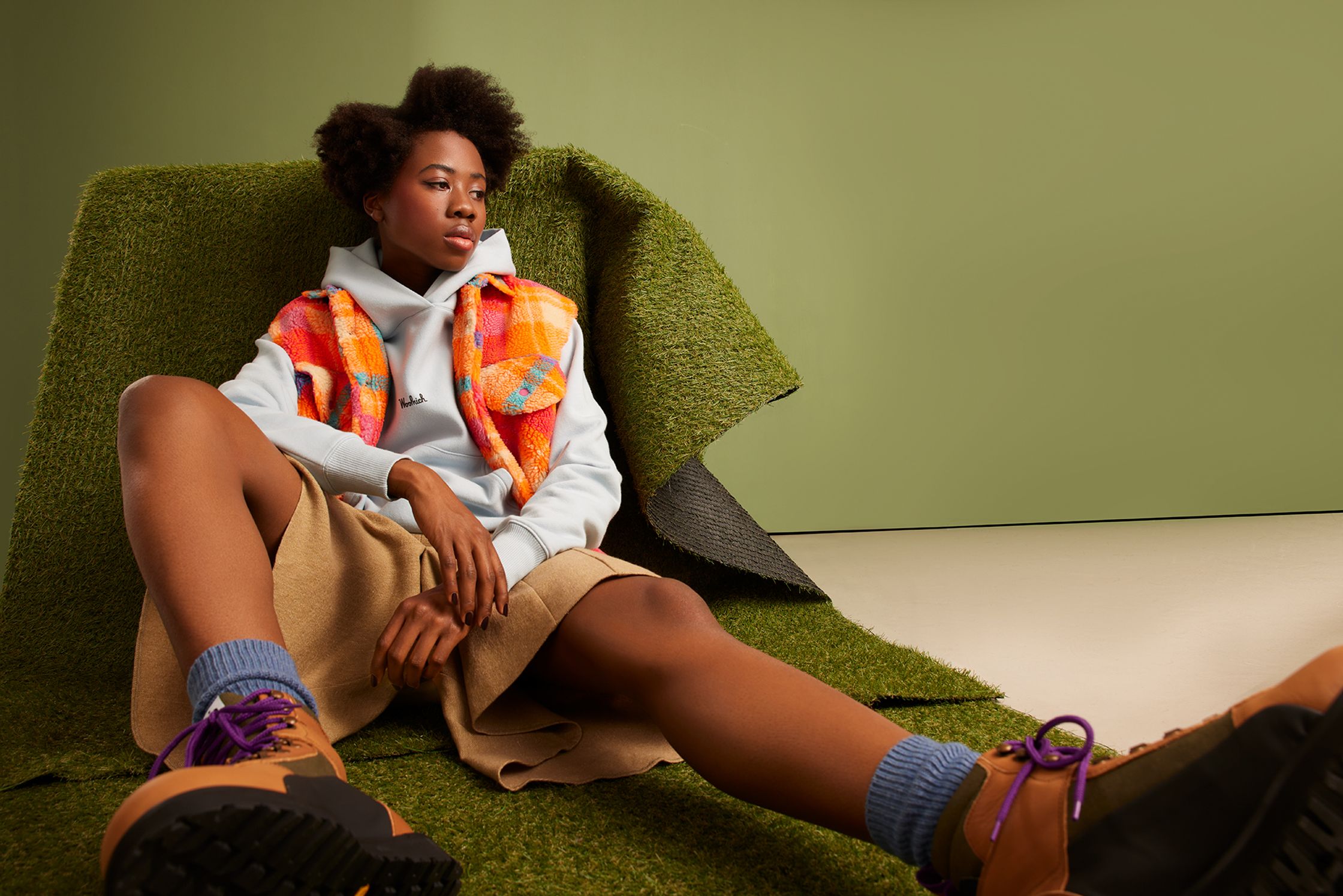 a black woman sitting on a green rug