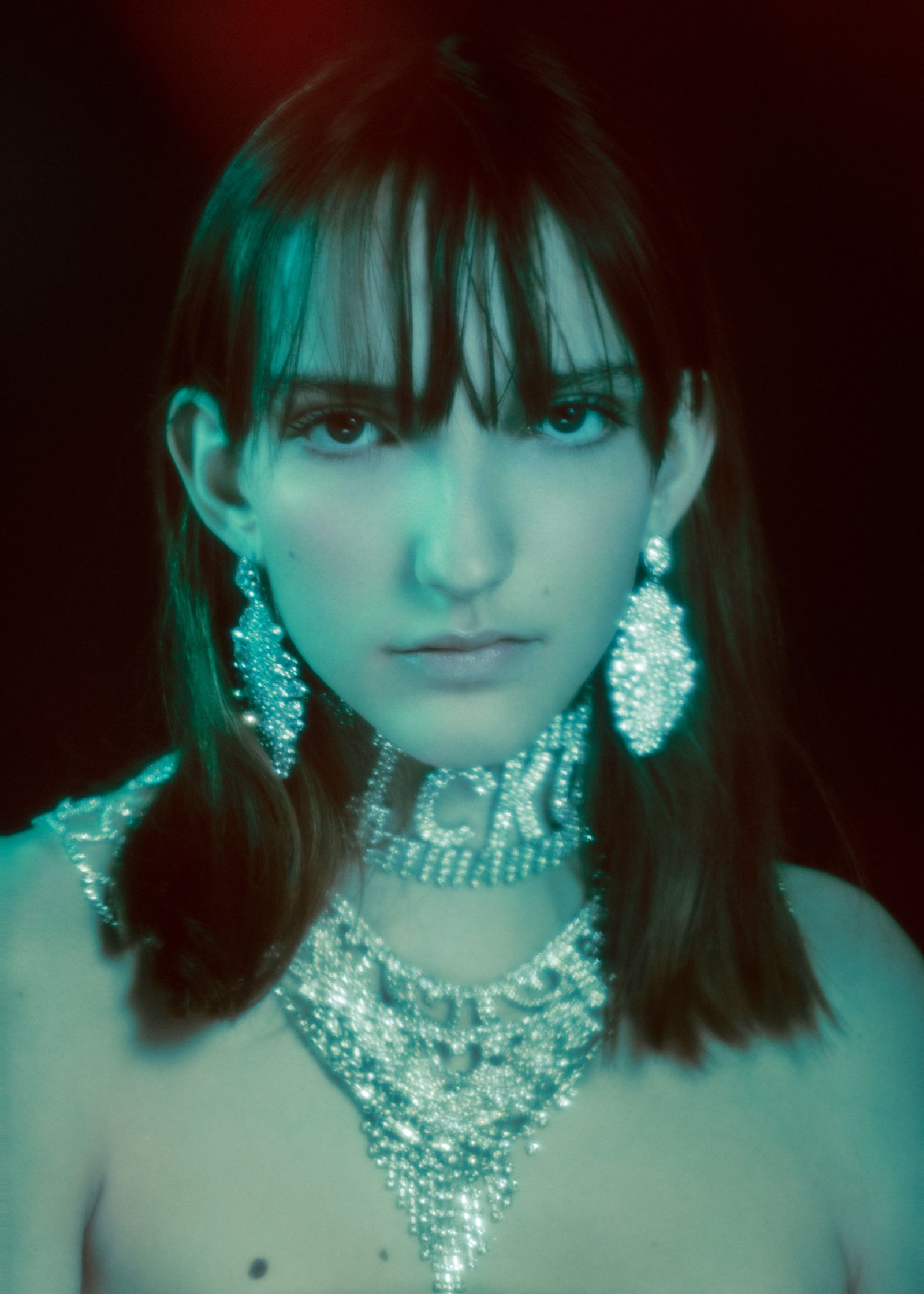 a woman with a necklace and earrings posing for a photo