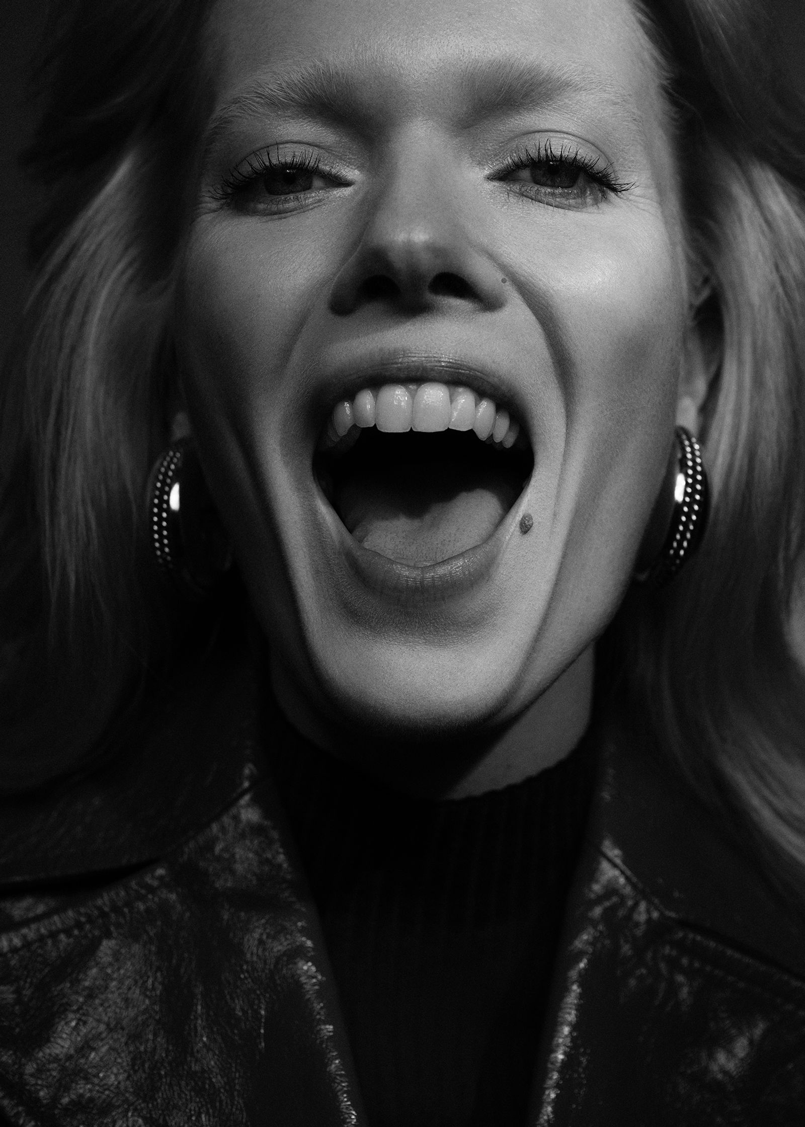 a black and white photo of a woman laughing