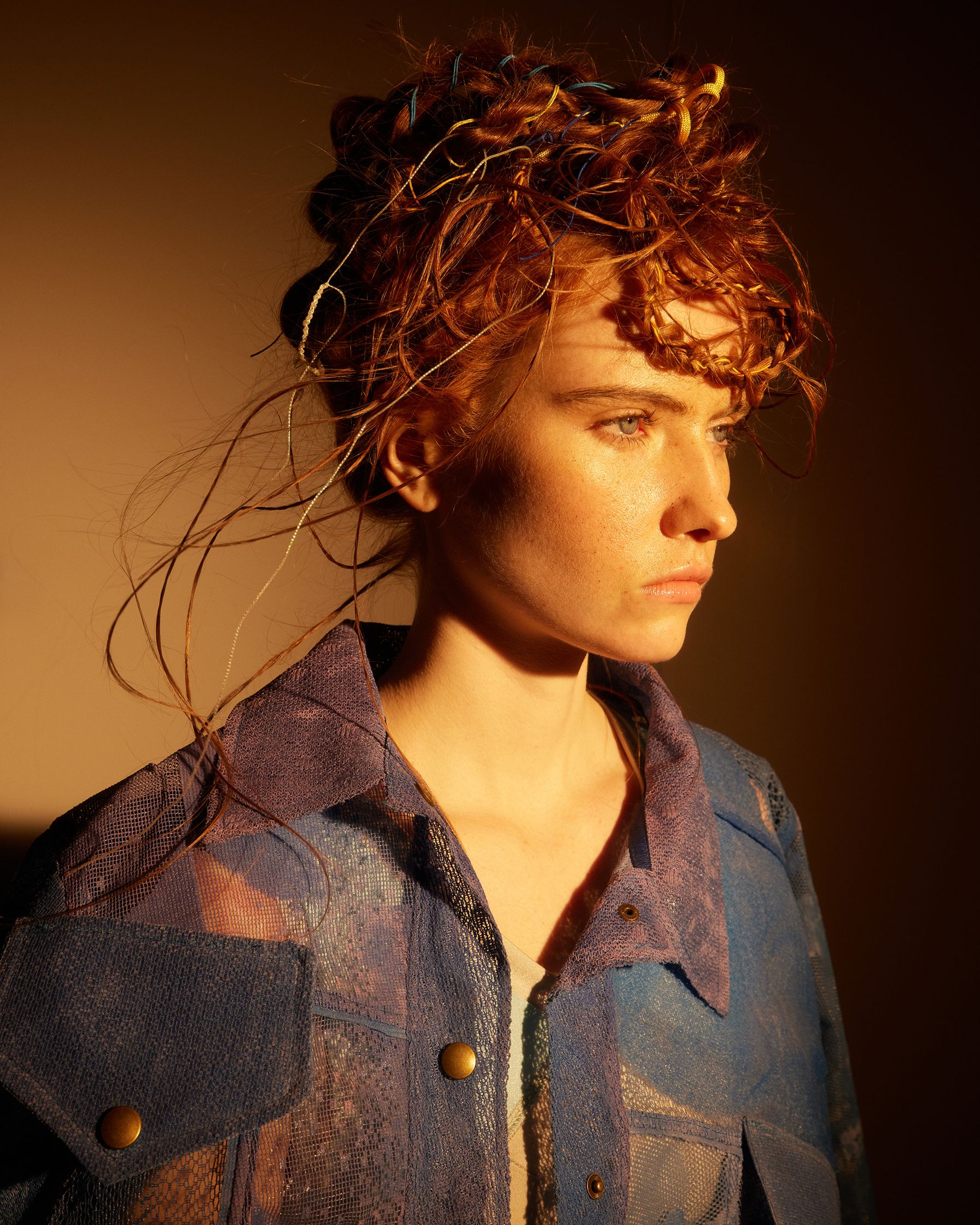a woman with red hair in a blue jacket