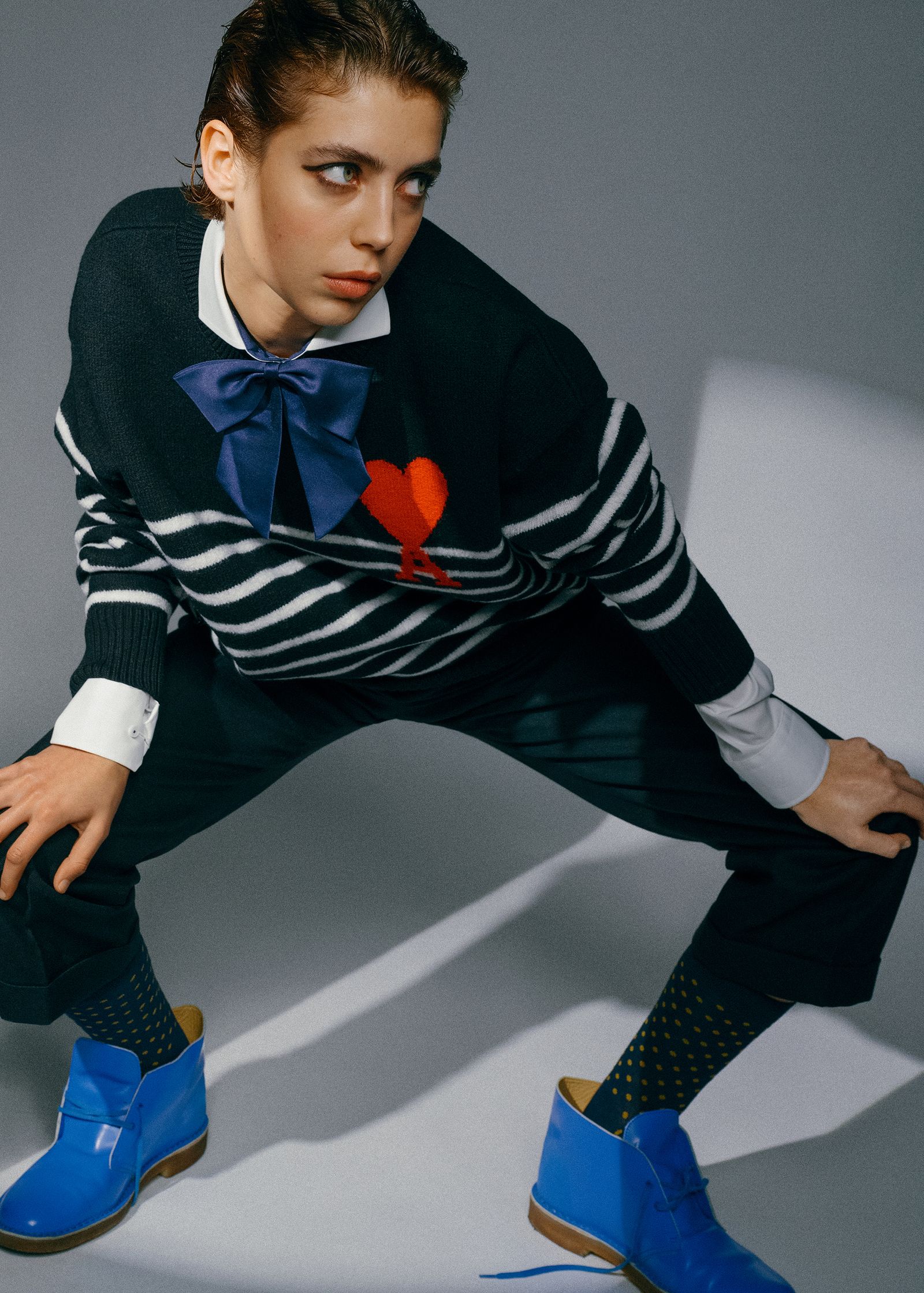 a woman in a striped sweater and blue shoes