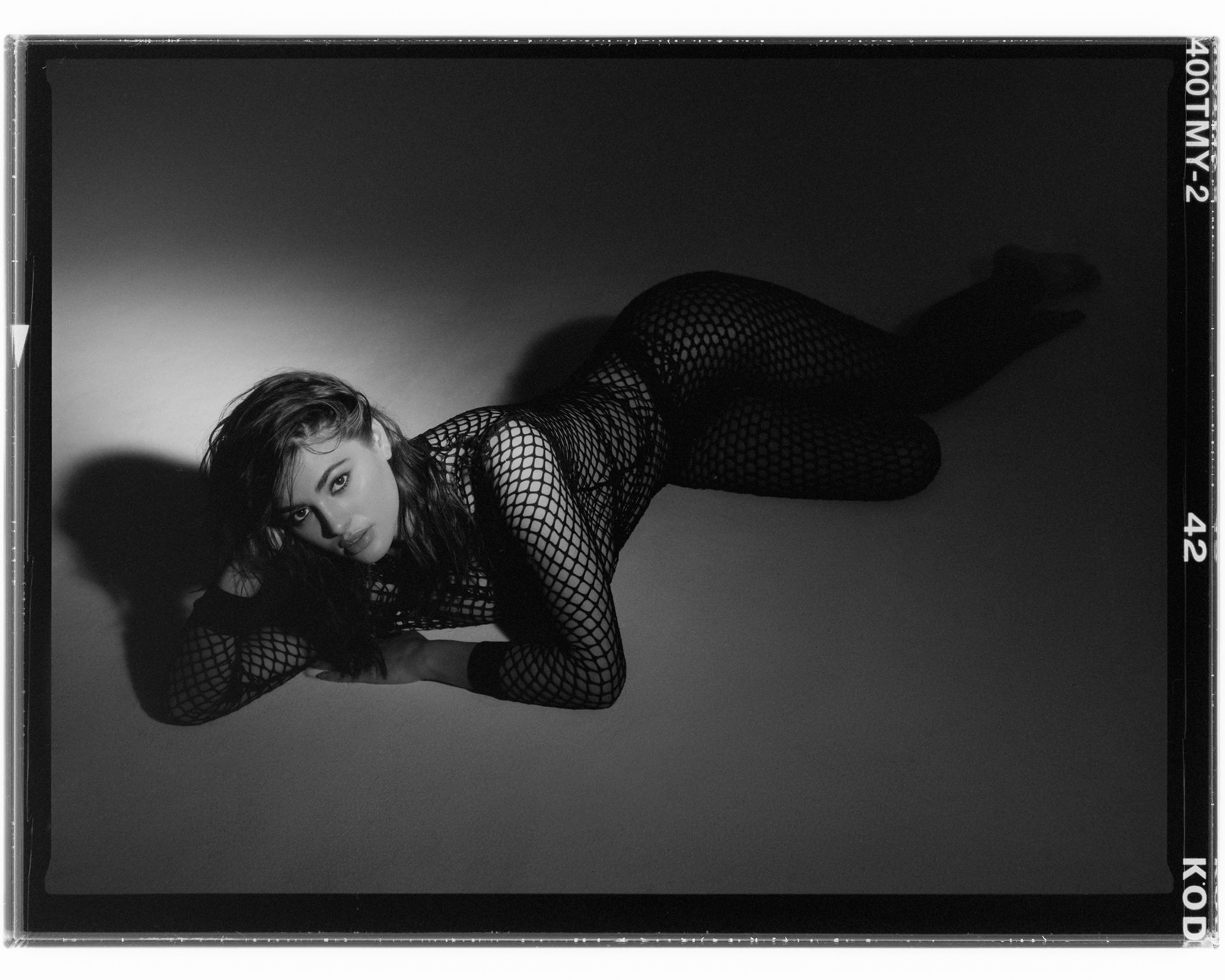a black and white photo of a woman laying on the floor
