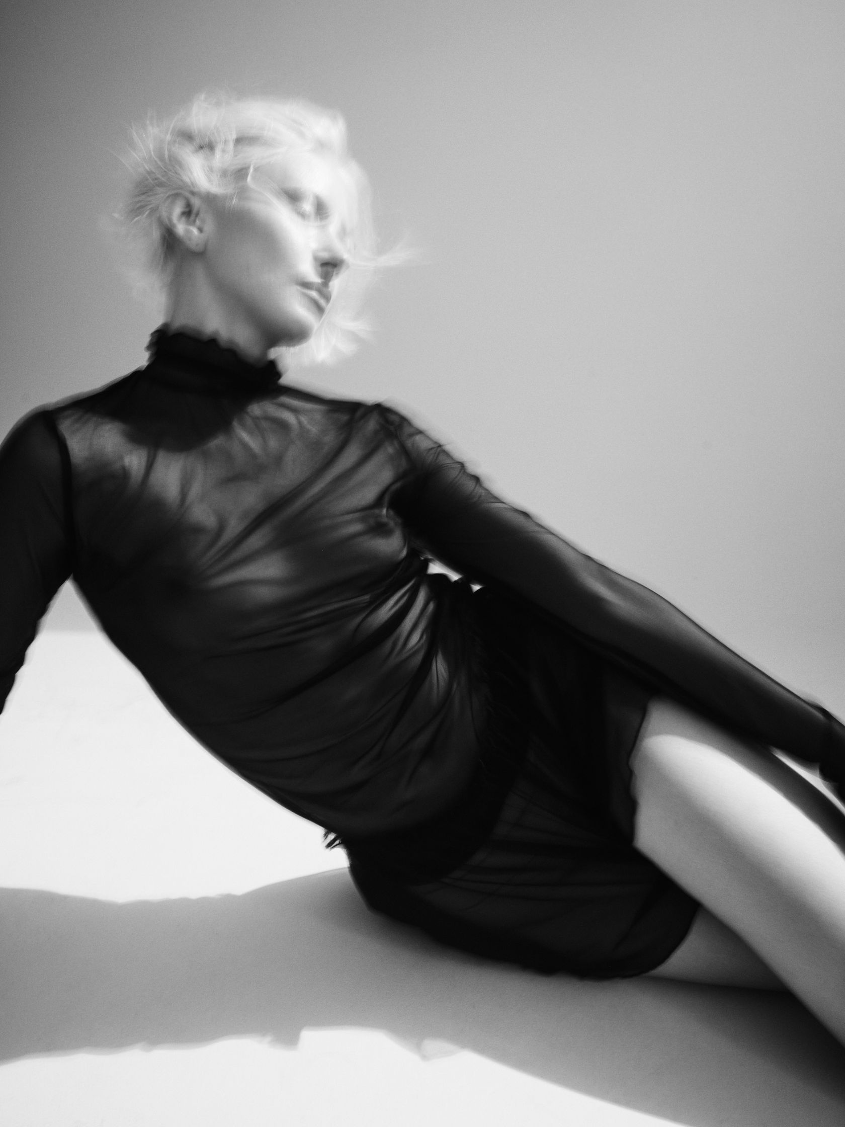 a black and white photo of a woman laying on the floor