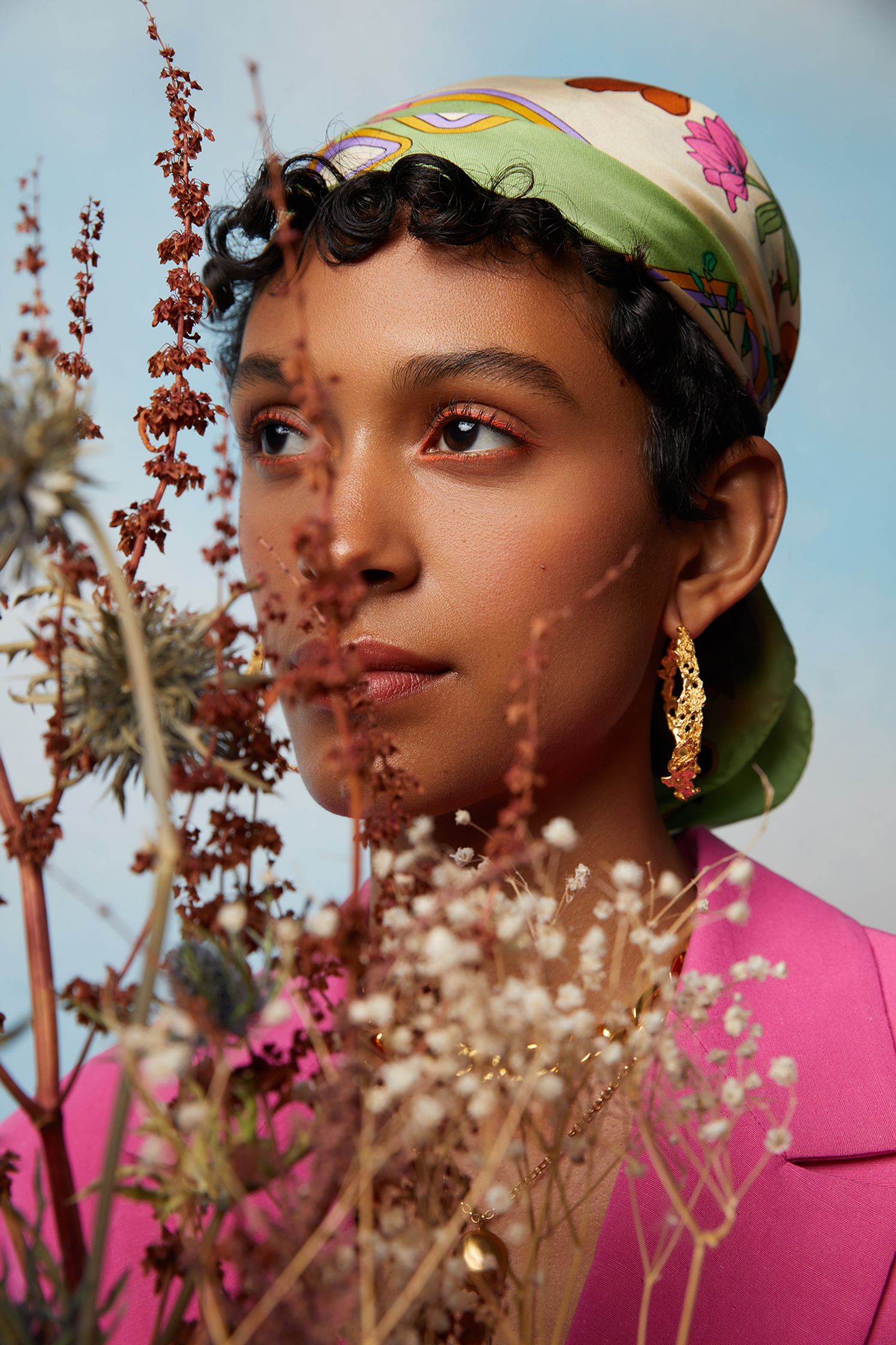 a woman in a pink jacket with a flower in her hair