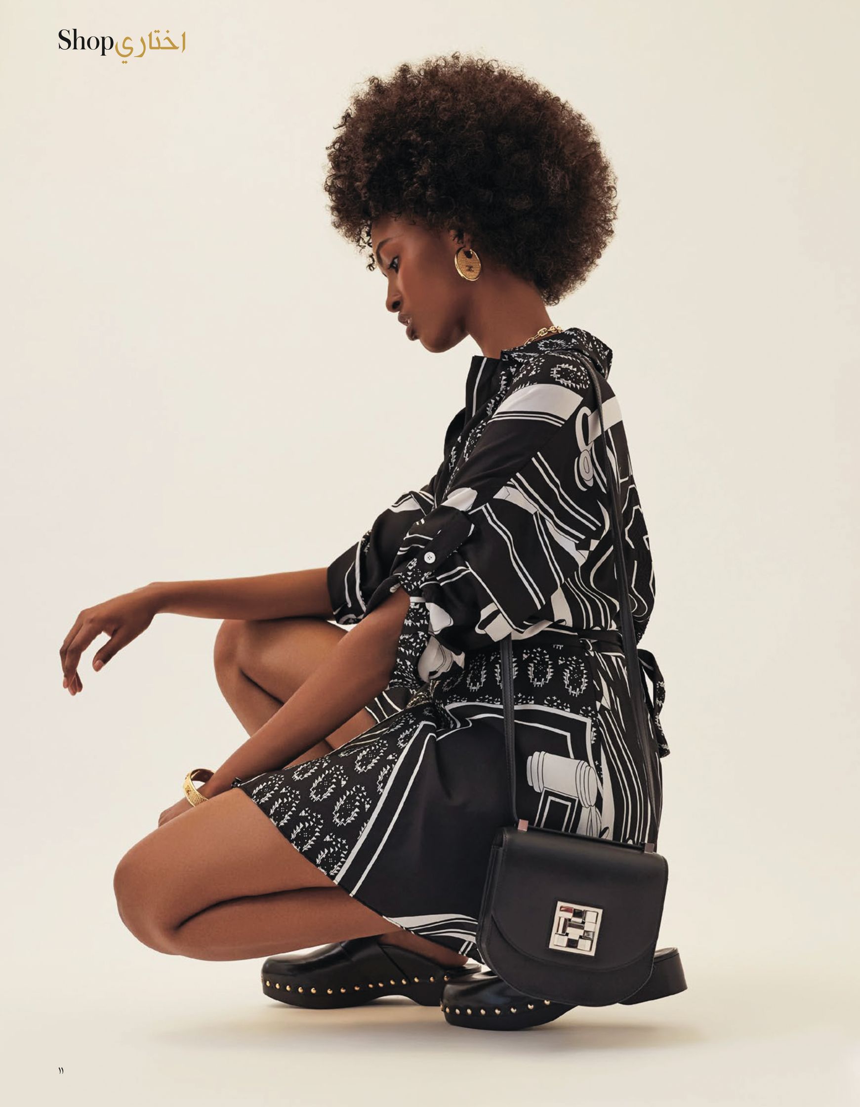 a woman in a black and white dress crouching on the ground
