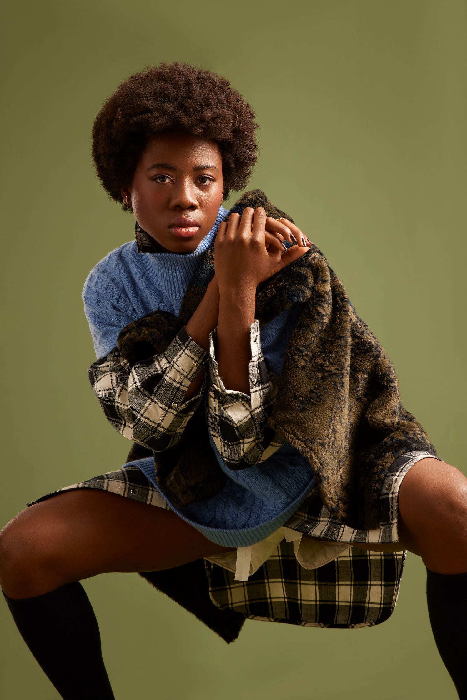 a black woman posing in a plaid shirt and tights