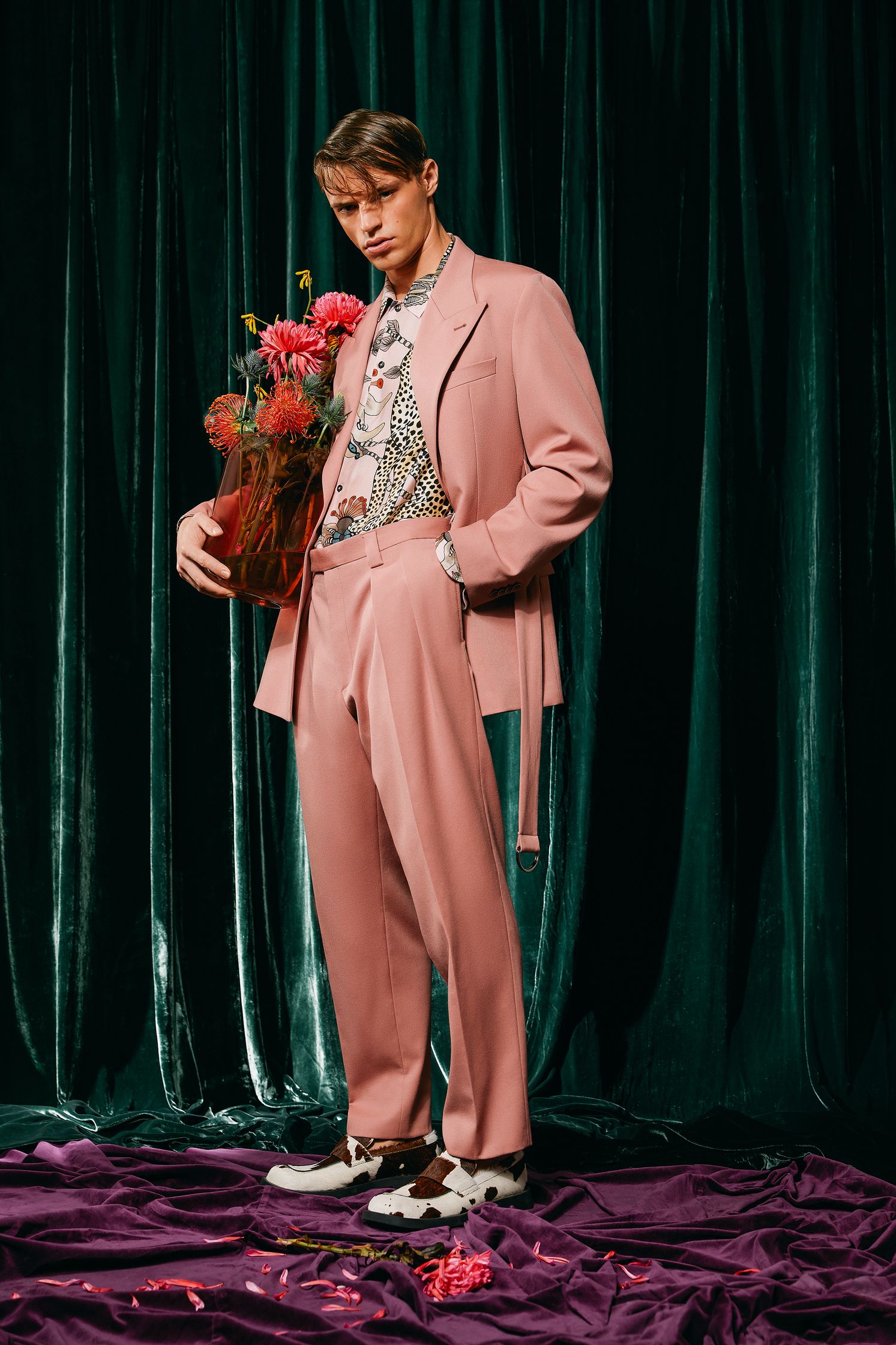 a man in a pink suit holding flowers