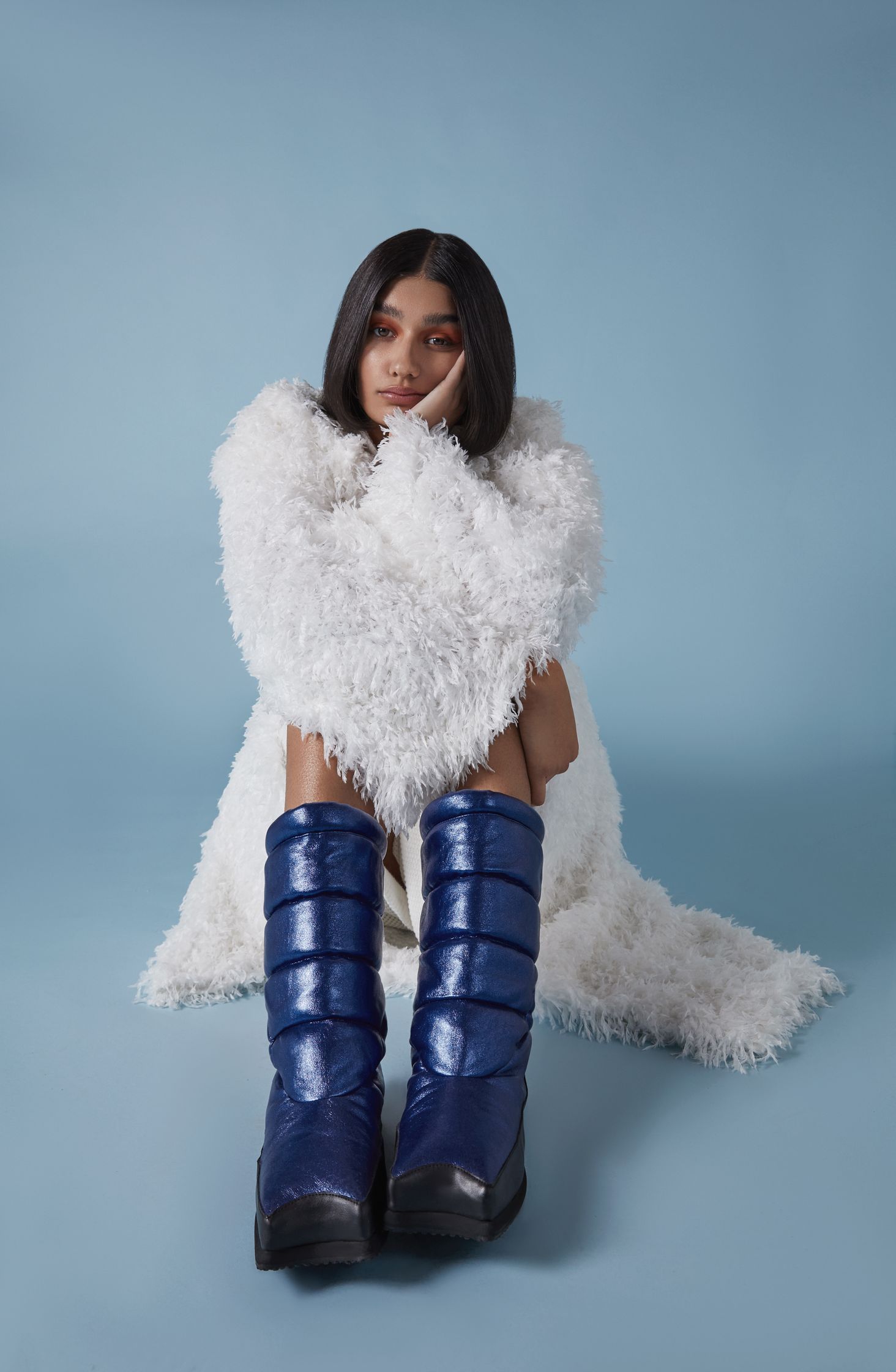 a woman wearing a fur coat and blue snow boots