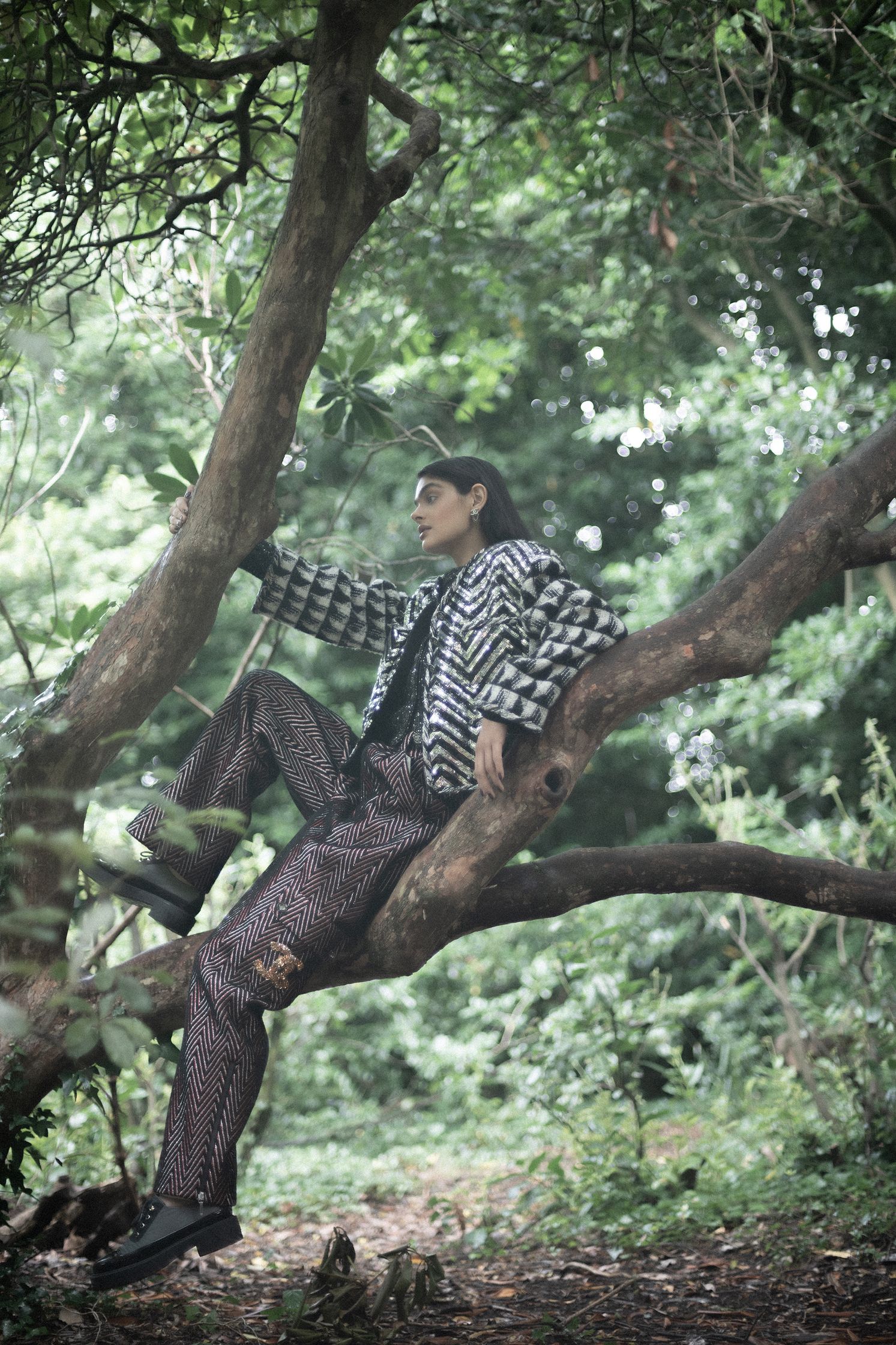 a man sitting on a tree in the woods