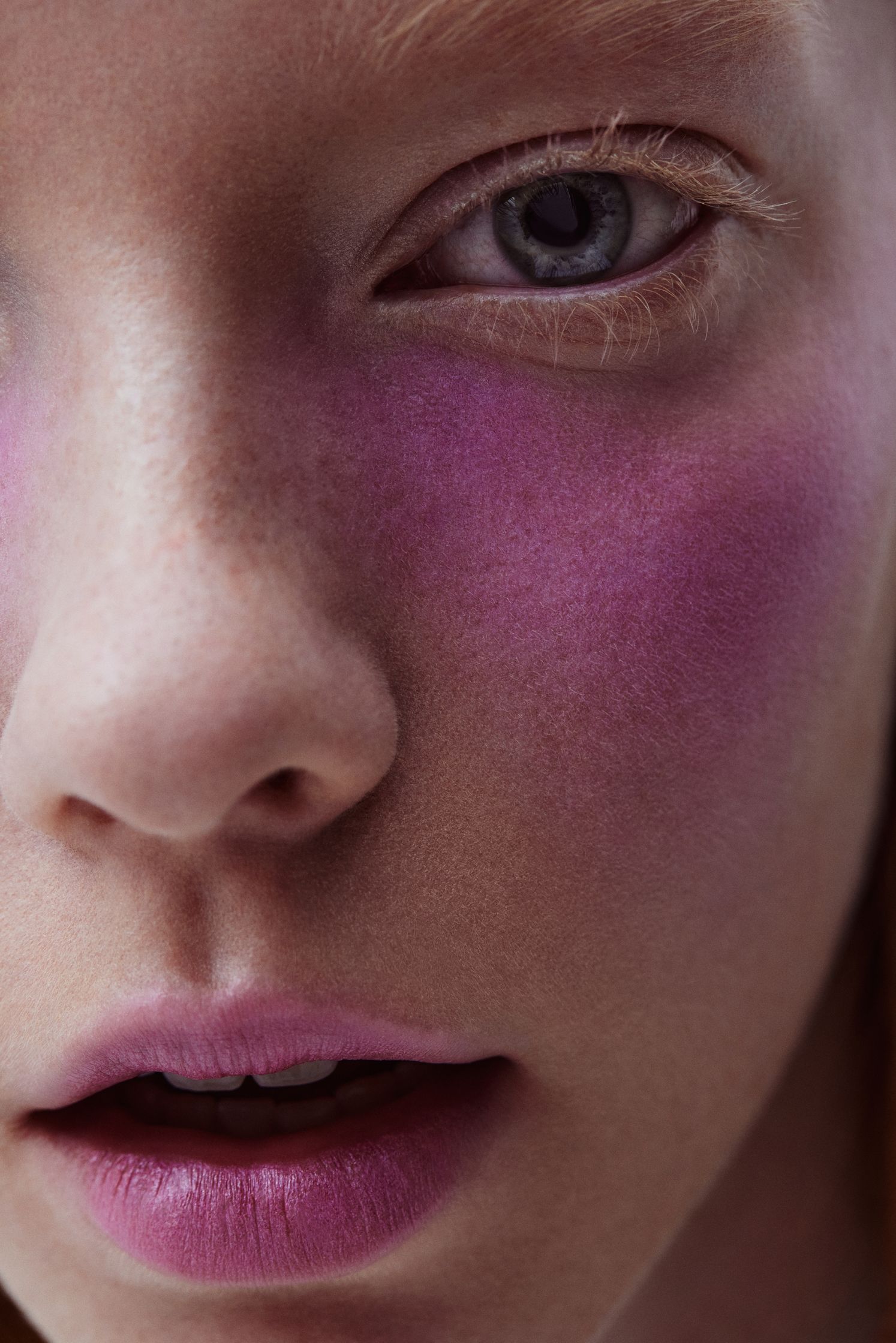 a close up of a girl with pink makeup on her face
