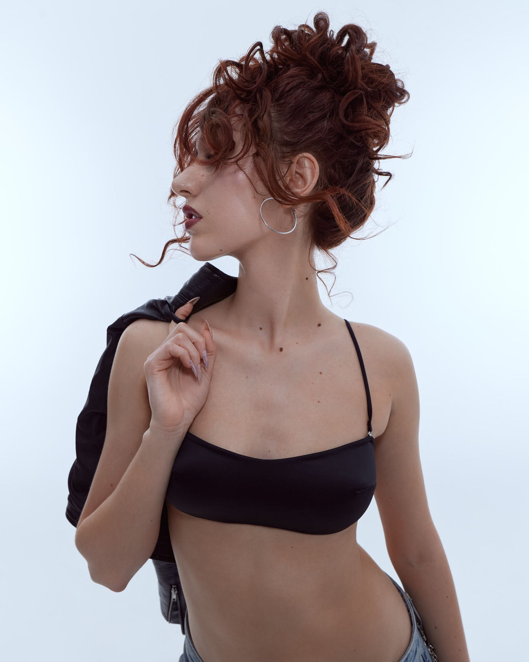 a woman in a black bikini posing on a white background