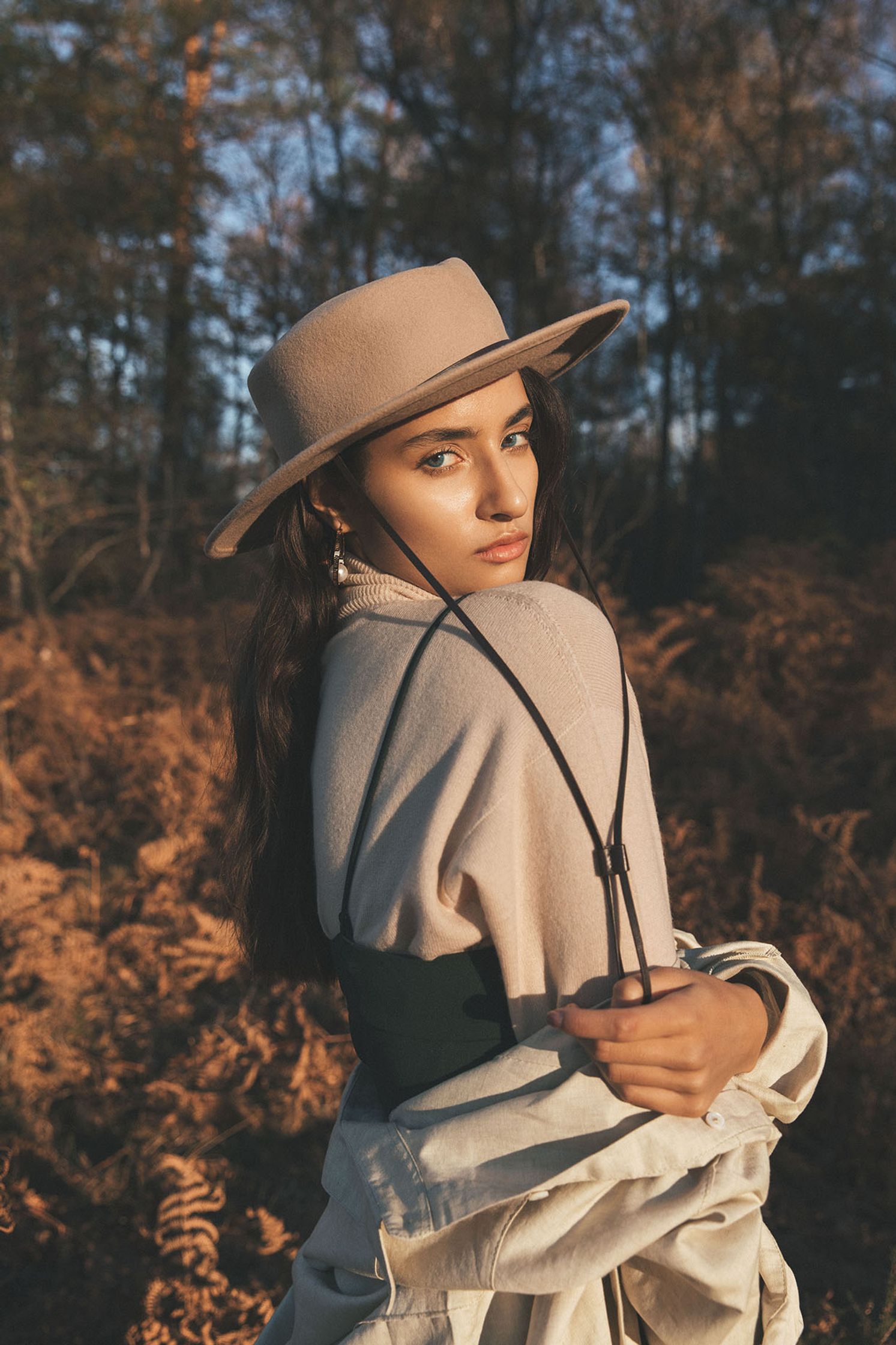 a woman wearing a hat in a forest