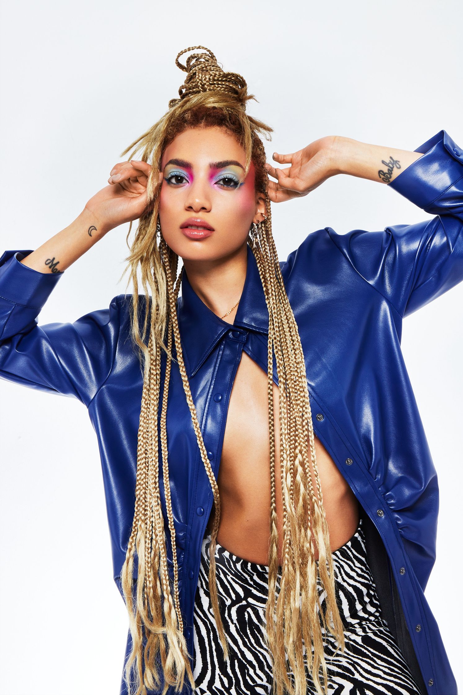 a woman wearing a blue jacket and zebra print pants