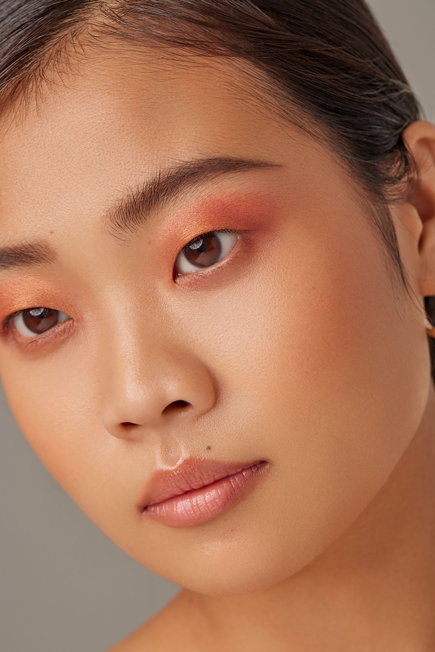 asian woman with a bright orange eye makeup