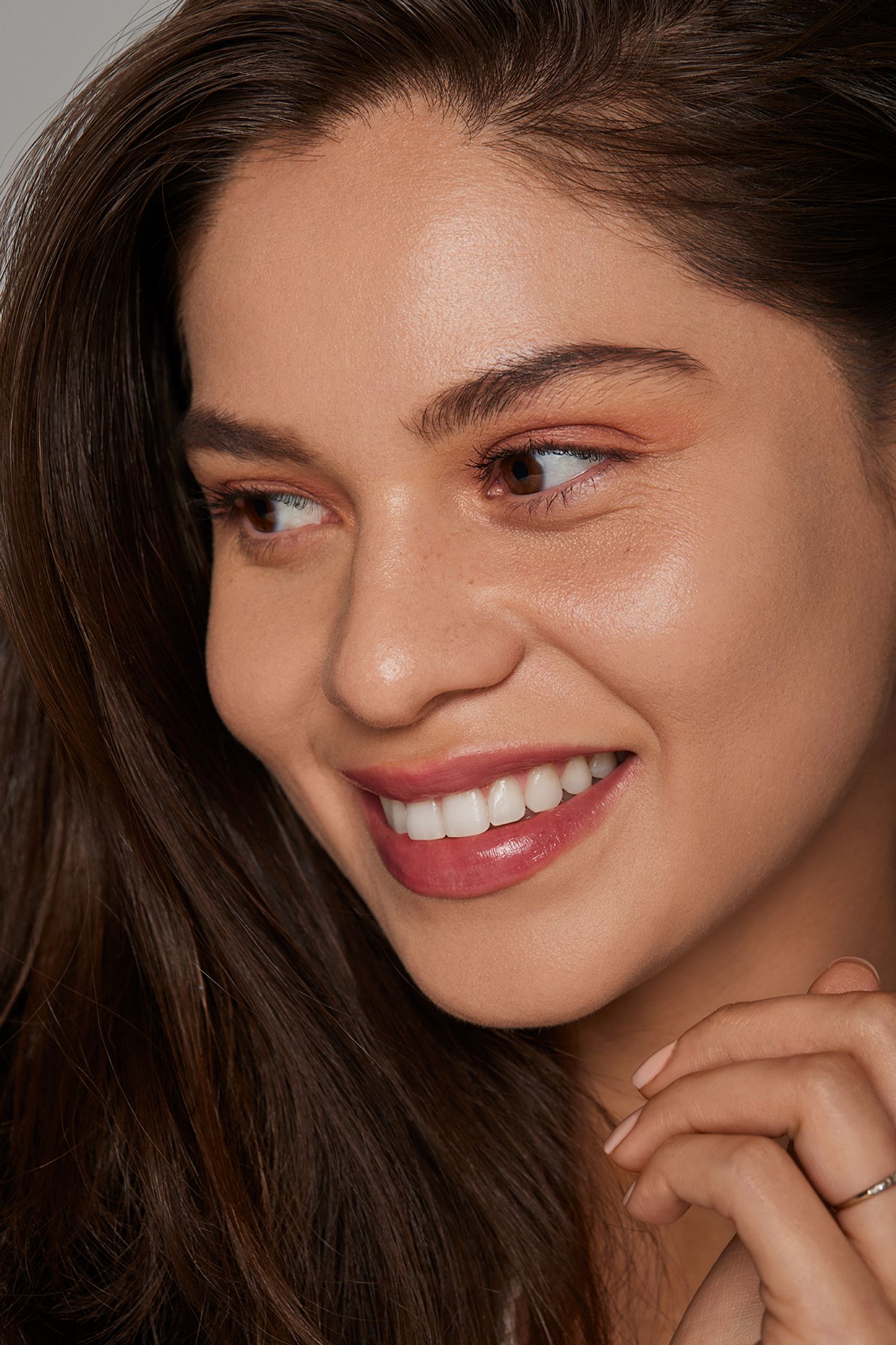 a woman smiling with her hand on her chin