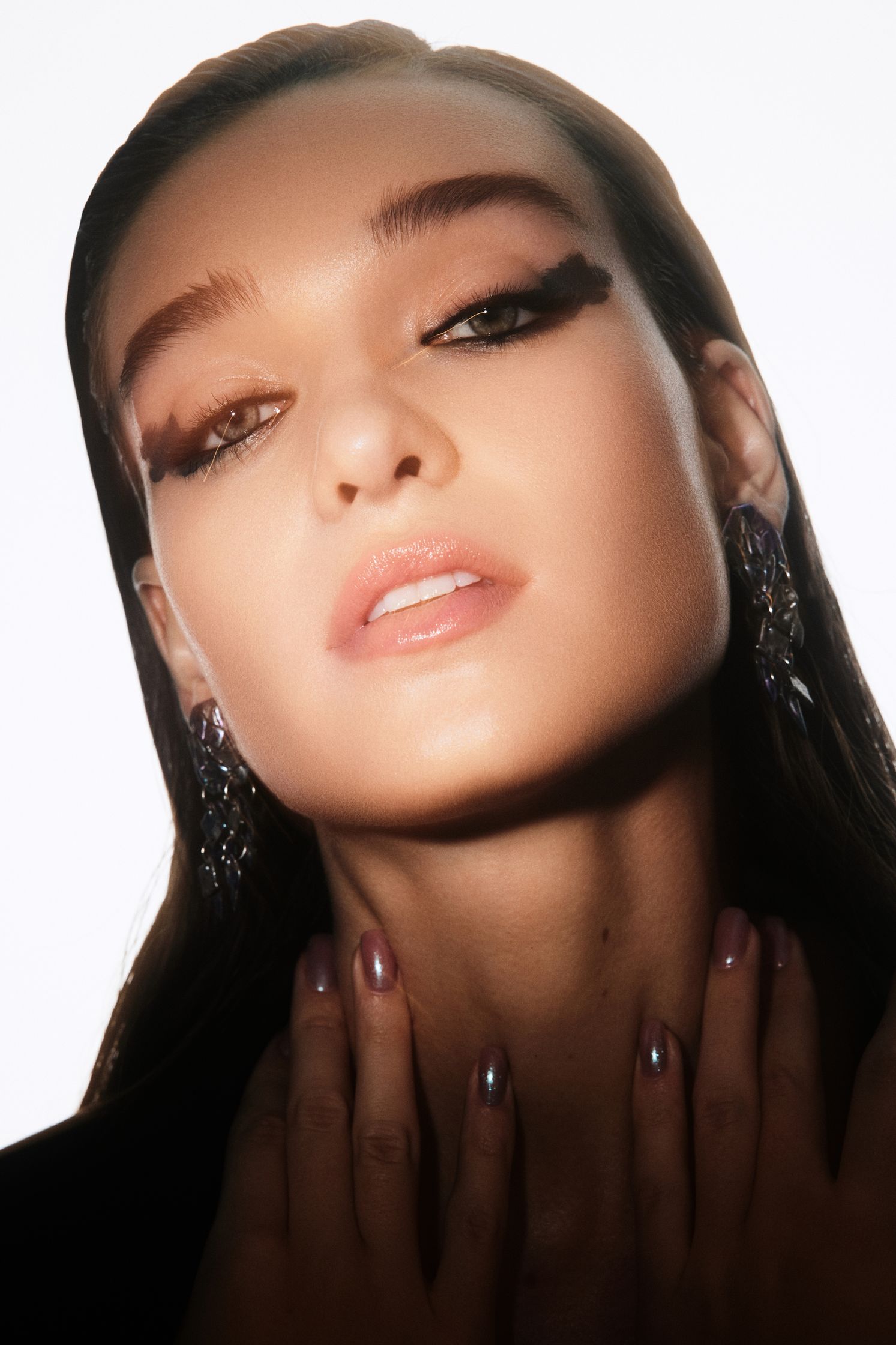 a woman is posing with her hands on her face
